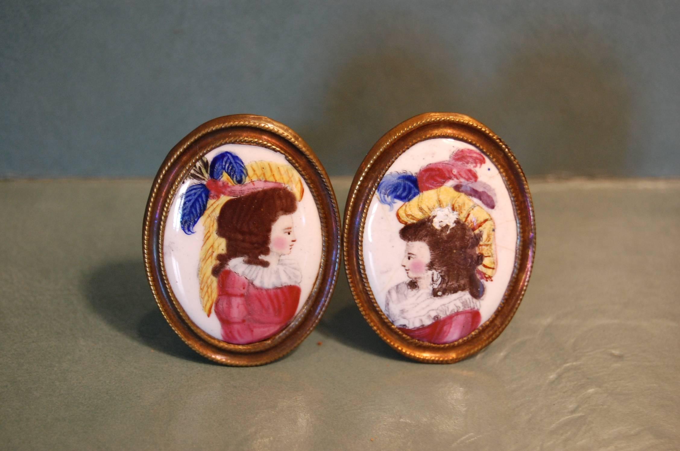 Wonderful pair of oval tiebacks featuring 18th century ladies of fashion. These women were purported to be actresses of the day when we purchased these tiebacks back in the 1960s.