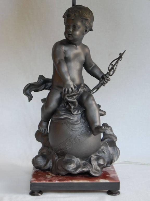 This lead figure has been recently lacquered in a steel color and mounted onto a marble base and wired as a lamp with a three-way socket. It is 17