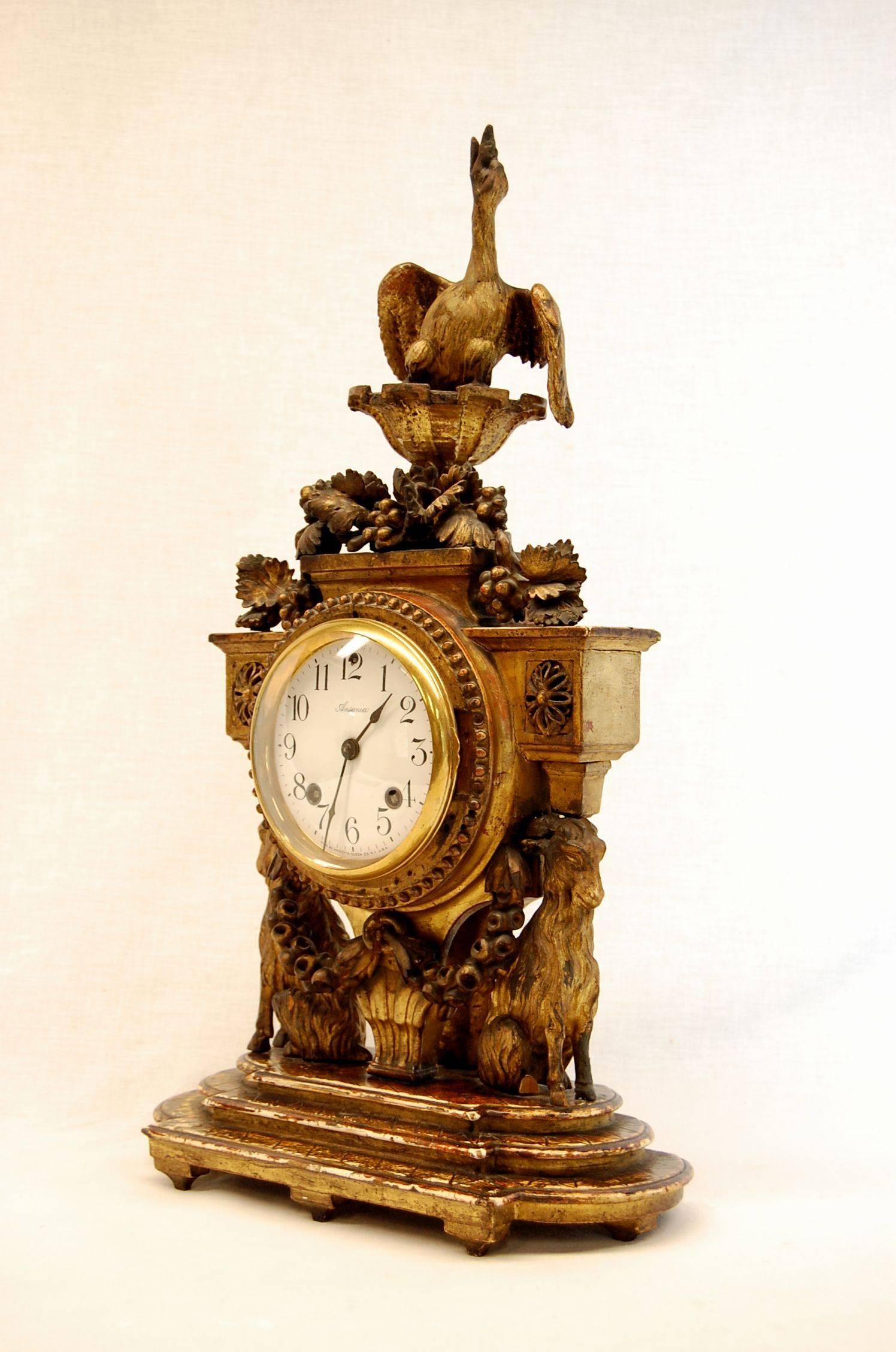 Gilded carved wooden shelf clock with bird finial and ram figure supports with Ansonia works (may have been added later).