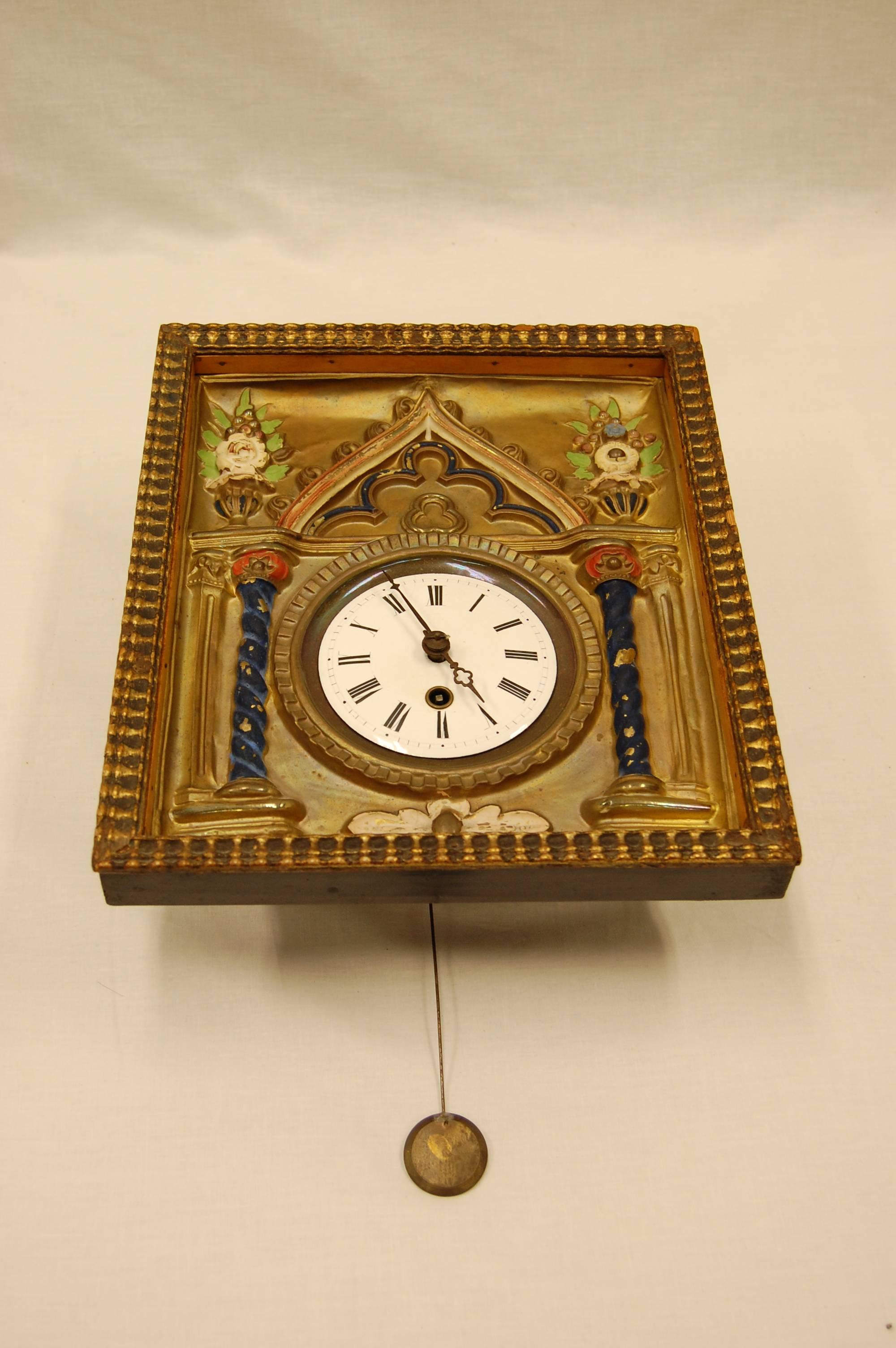 Brass repousse and enamel wag-on-wall clock with enameled dial and roman numerals. While we have owned this clock for many years, we have never attempted to check to see if it keeps time. The key does wind the mechanism and it will run for a time,