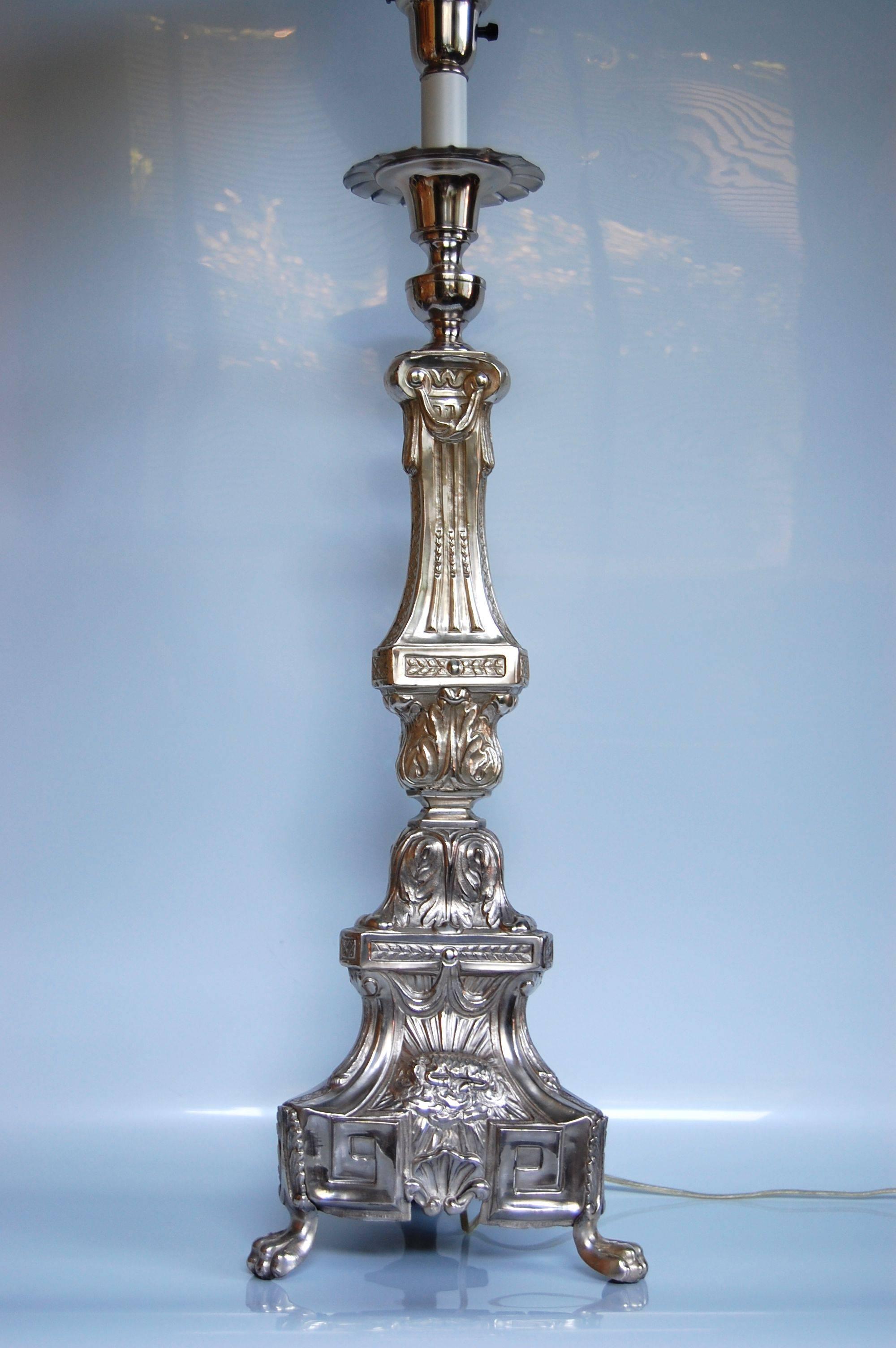 Large silver plate column table lamp that has been lacquered. Decorated with a resting lamb, wheat, grape clusters and a religious symbol. The lamp was likely made from a mid-19th century altar candlestick that was not wired until the late 20th