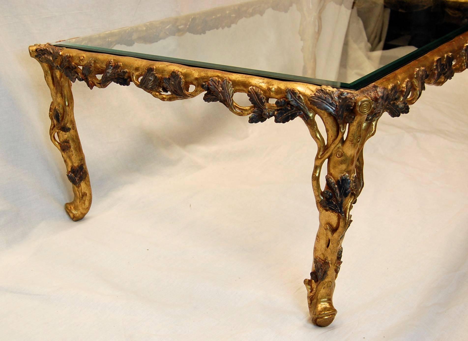 This rectangular coffee table is carved to simulate tree branches and leaves and is in excellent condition. Measures: The glass top is 5/16 in thickness and has a 3/4 inch bevel.