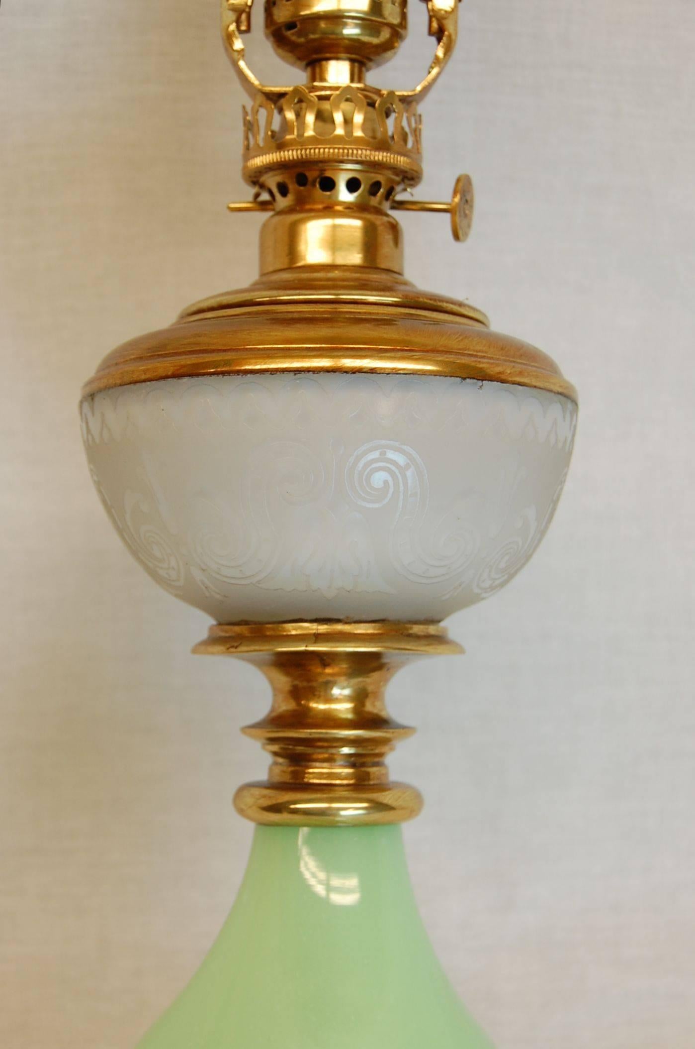 Pretty oil lamp with mint green glass base and cut frosted glass oil font resting on a brass base. Wired with a three-way socket and includes a new custom-made silk lampshade.