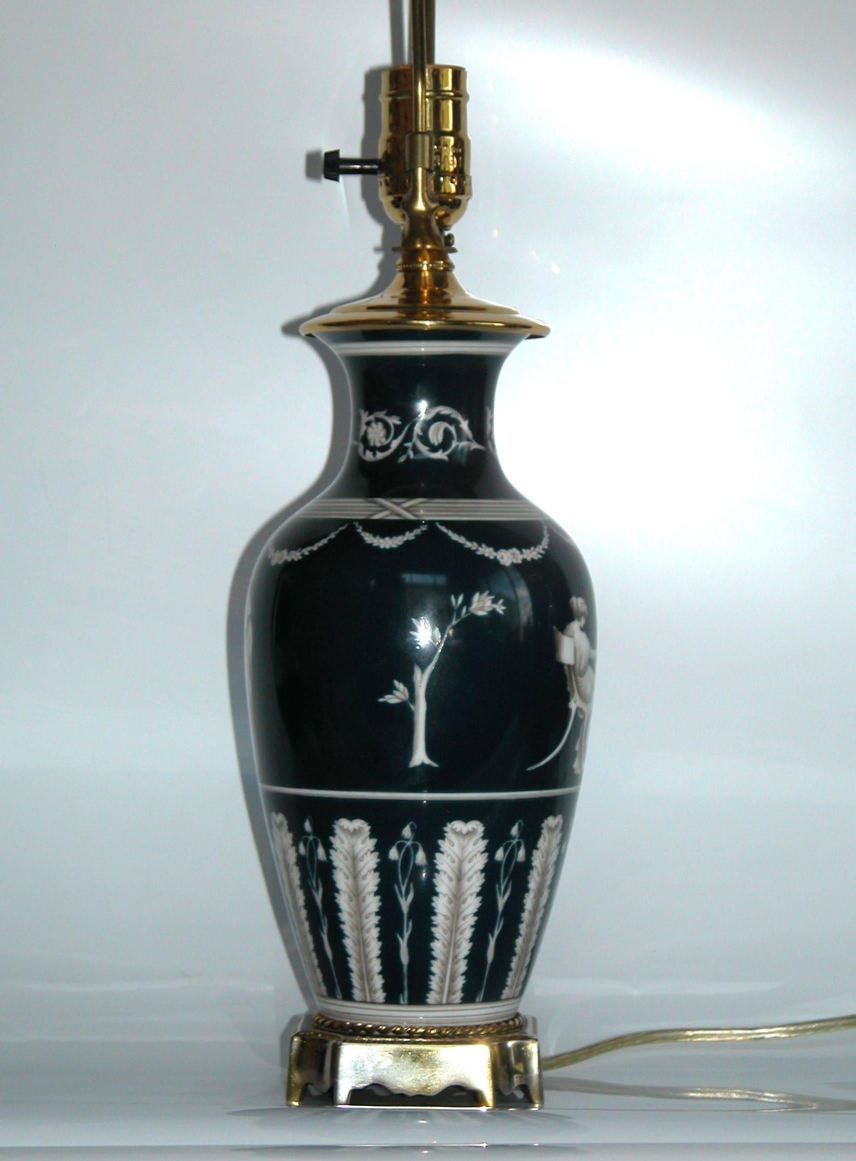 Classically inspired theme circling the vase, recently rewired, cleaned and polished. The vase itself (with base) measures 10 inches tall.