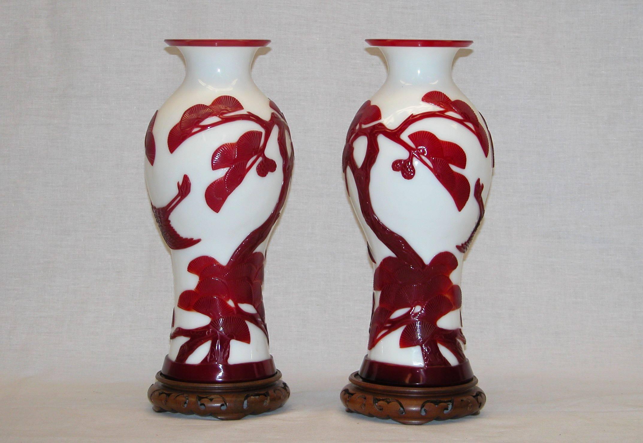 Pair of mint condition glass urns on wooden bases in excellent condition, late 19th century. Red over white glass design including birds in flight and extremely well-done Chinese branches and leaves.