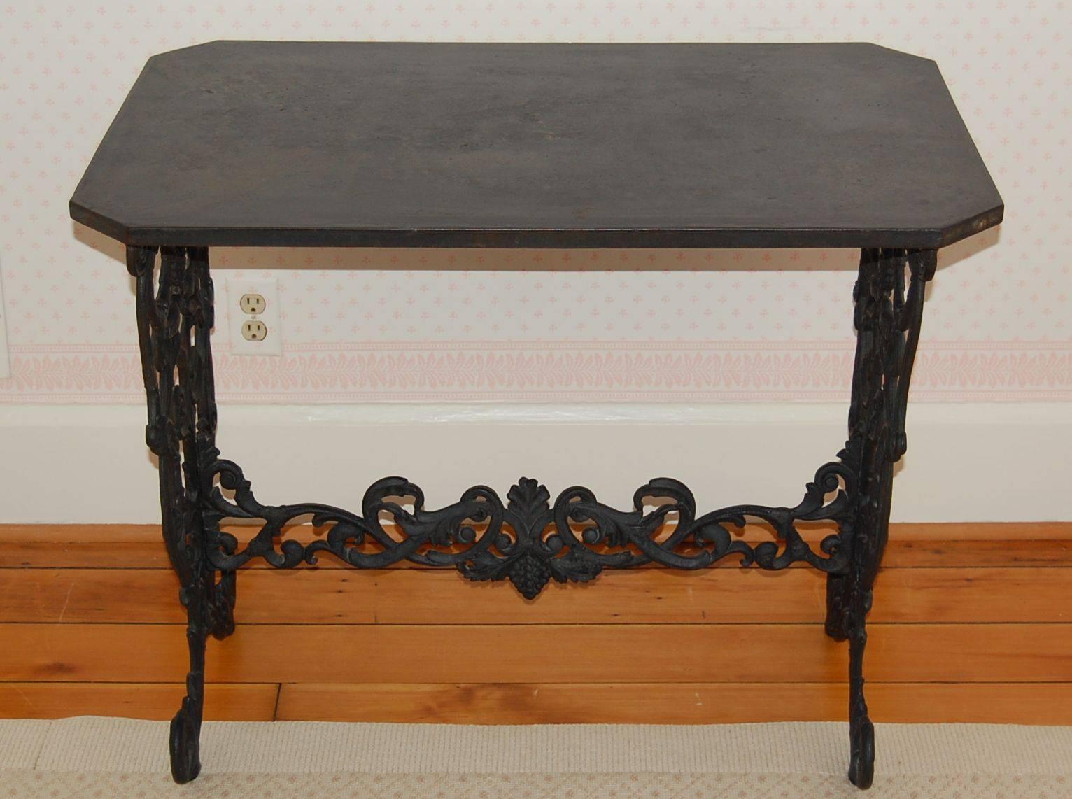 Elaborate cast iron table base with the original cast iron top in black painted finish circa 1870. The base consists of wonderful upturned eagles heads, grapes and other birds.
