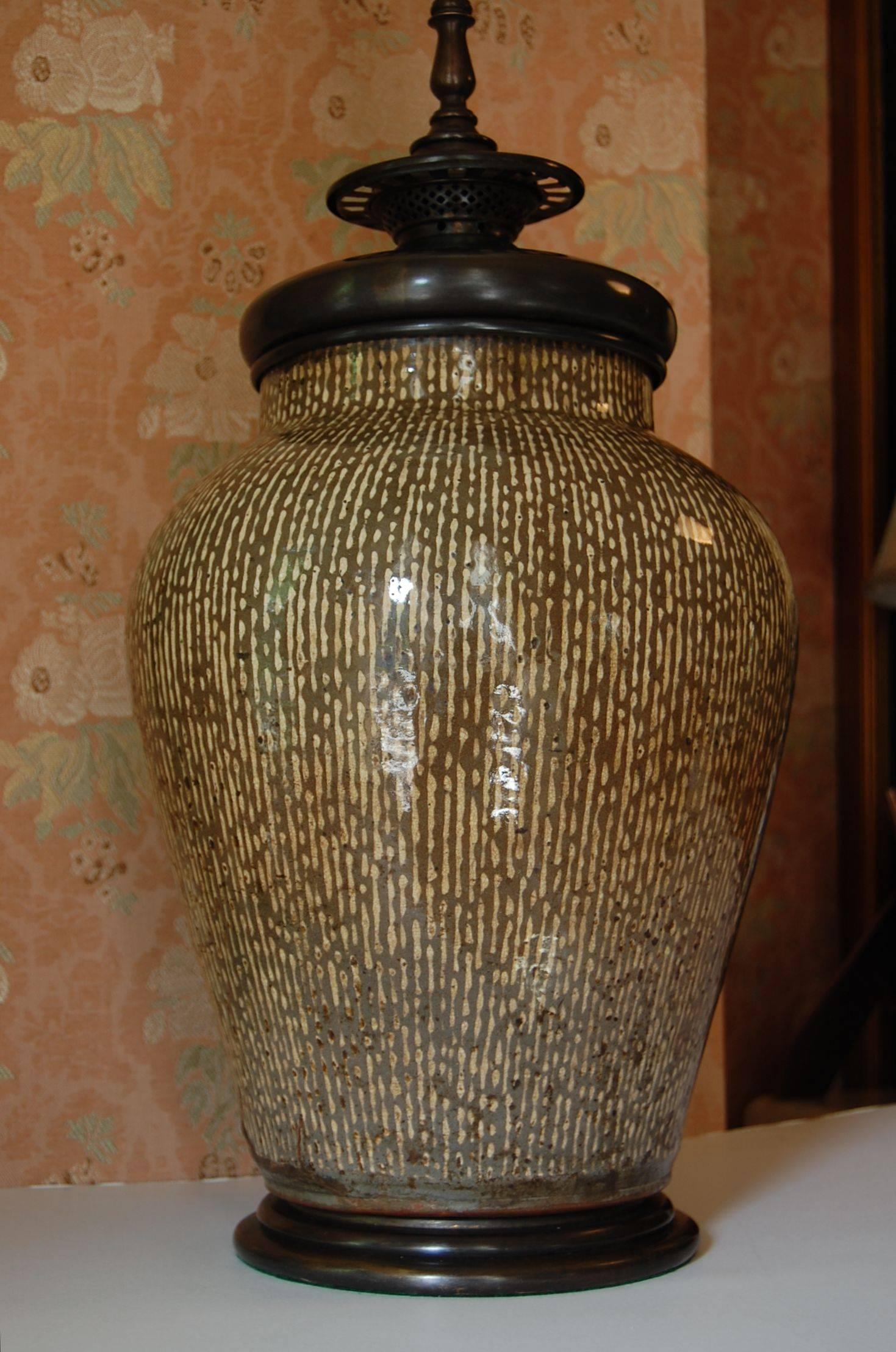 Wonderful large Asian, possibly Chinese or Korean urn wired as a lamp with original turn of the century brass base and fittings. Olive and ecru colored strie' glaze. Just cleaned and rewired with a three-way socket. Measures: 15" to the top of