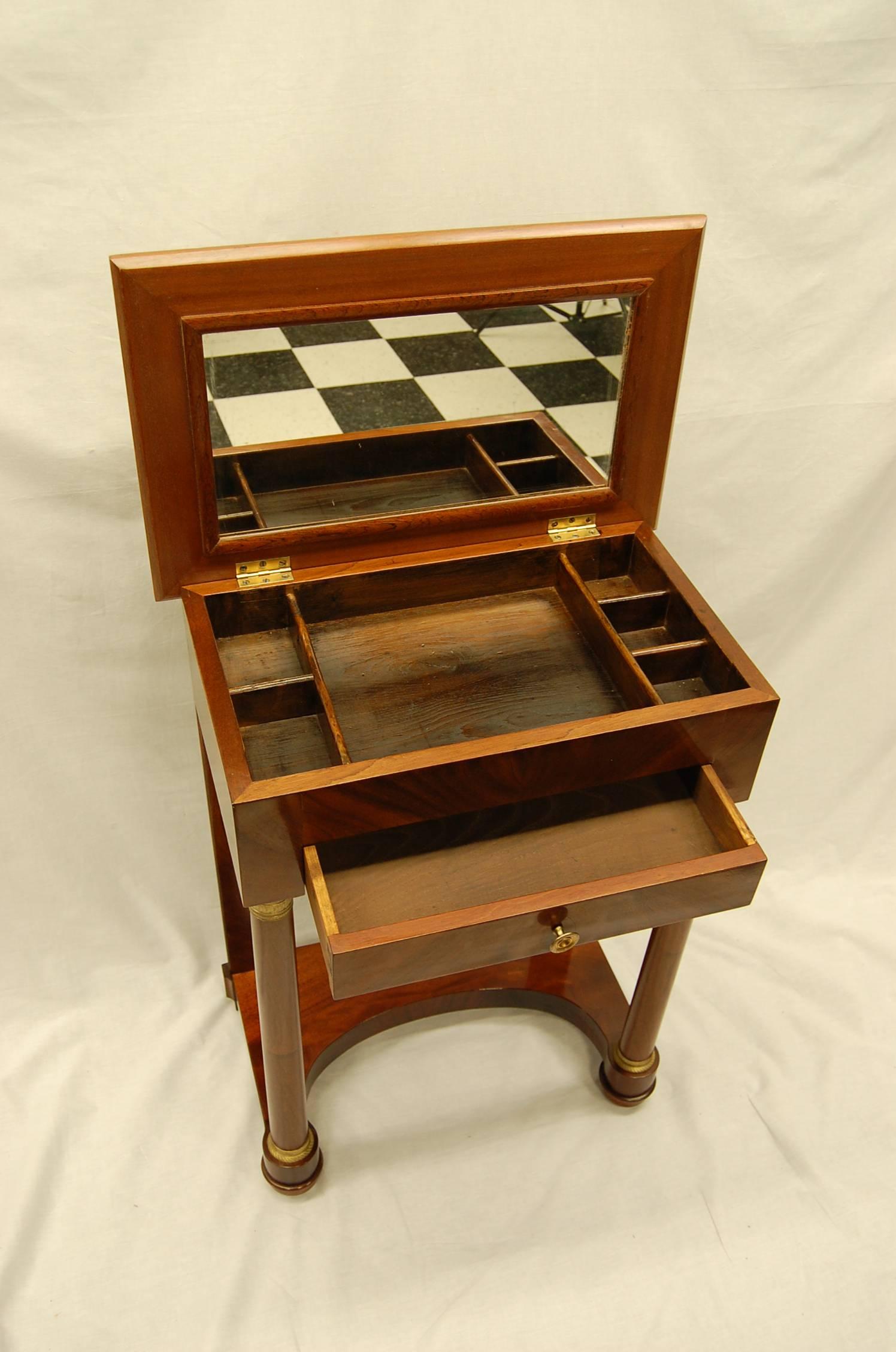 Beautiful wood grain and the shape makes this a particularly useful mahogany sewing table with lift up lid and mirror underneath exposing a divided interior area. Recently cleaned and polished.