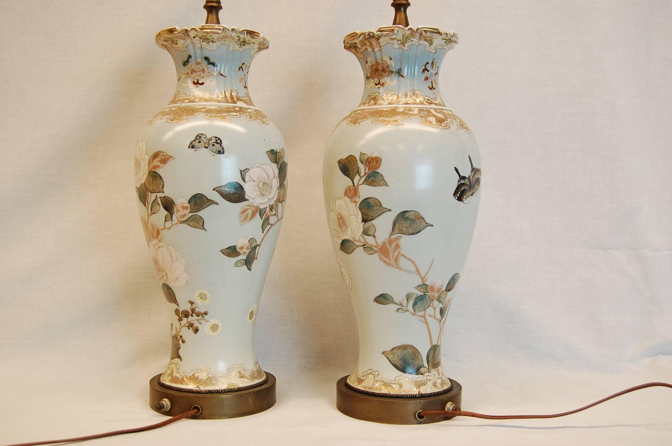 Pair of lamps with beautiful Magnolia blossoms decorations on a pale blue background. The urns themselves measure 15 1/4 inches tall. Excellent condition.
