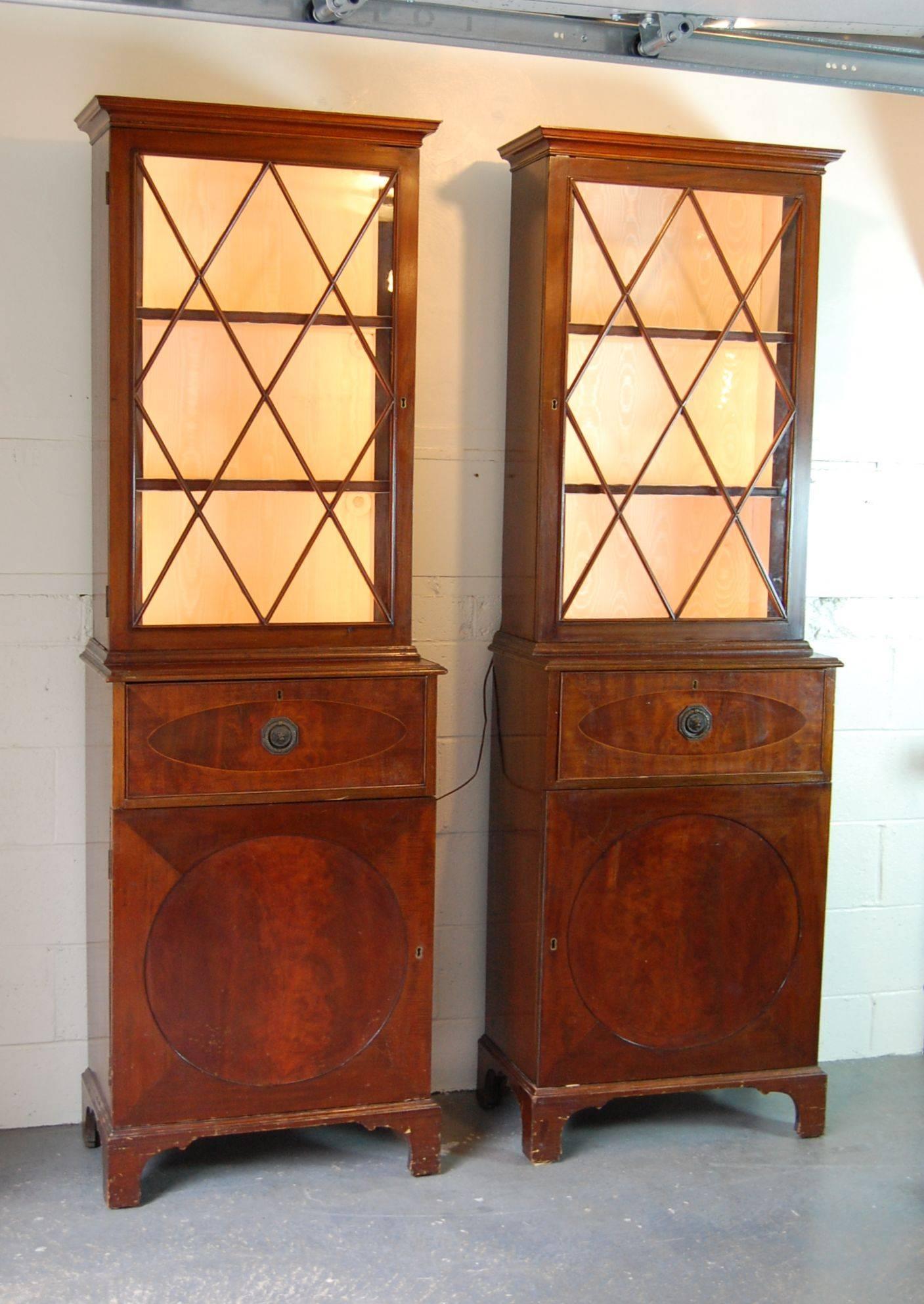 Pair of tall cabinets with lighted upper sections, cabinet bases and secretary drawer with drop down front.