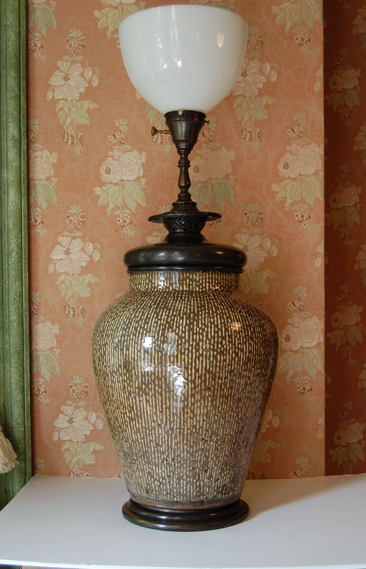 Wonderful large Asian, possibly Chinese or Korean urn wired as a lamp with original turn of the century brass base and fittings. Olive and ecru colored strie' glaze. Just cleaned and rewired with a three-way socket. Measures: 15