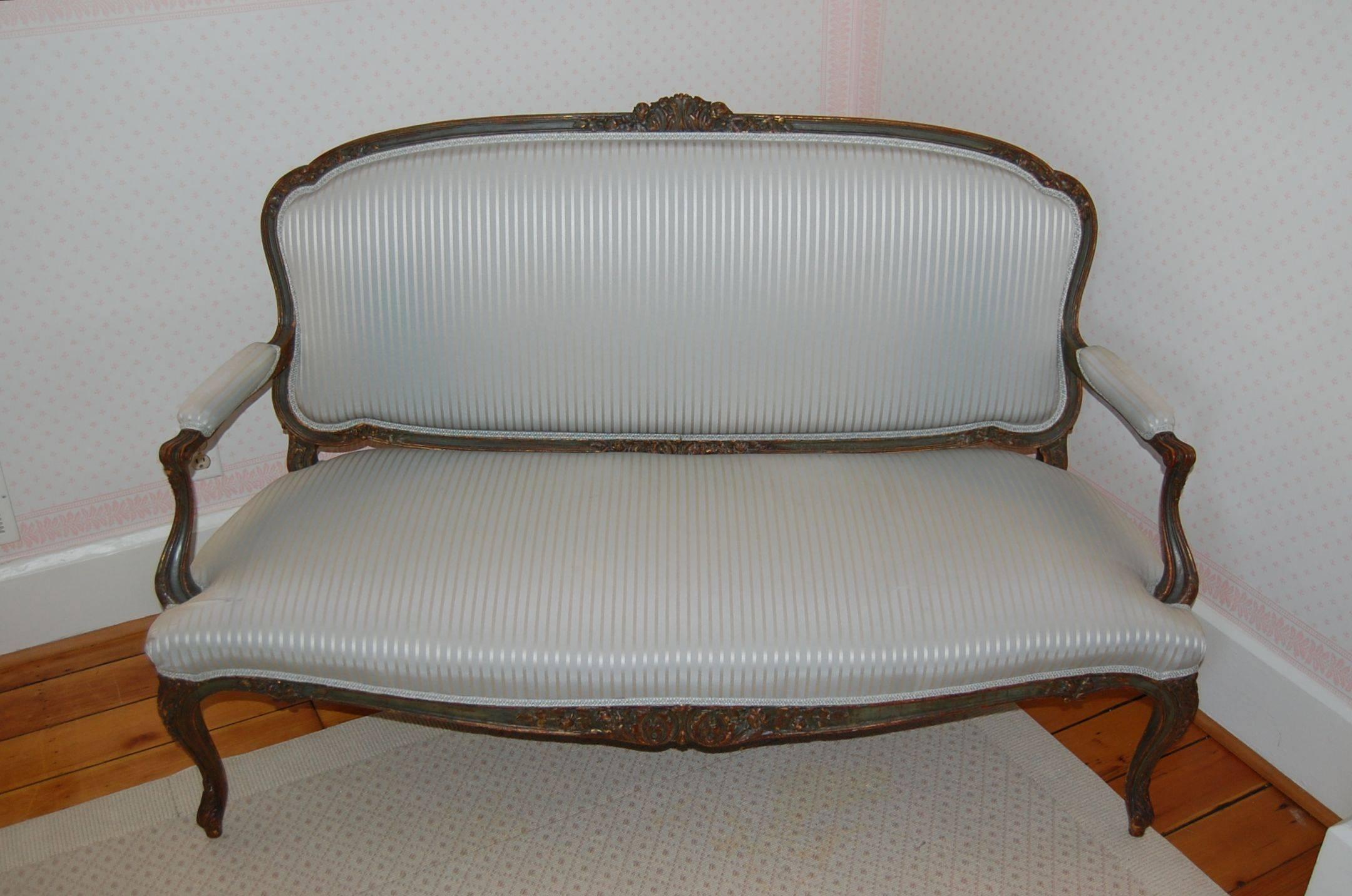 Brought to the US in the late 1920s, and was once part of a pair of settee. In original painted and gold leaf finish. Fabric has some sun damaged areas. 