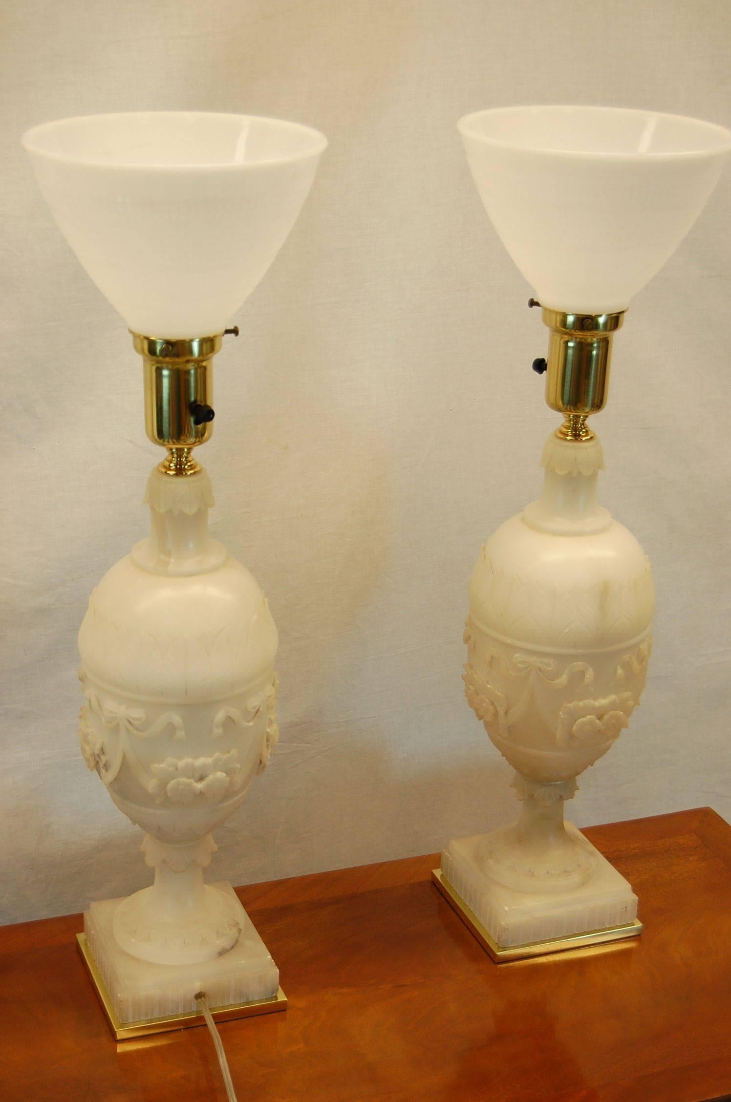 Pair of carved alabaster urn lamps in floral and swag motif, just rewired, cleaned and polished and in excellent condition. The alabaster urn itself measures 17