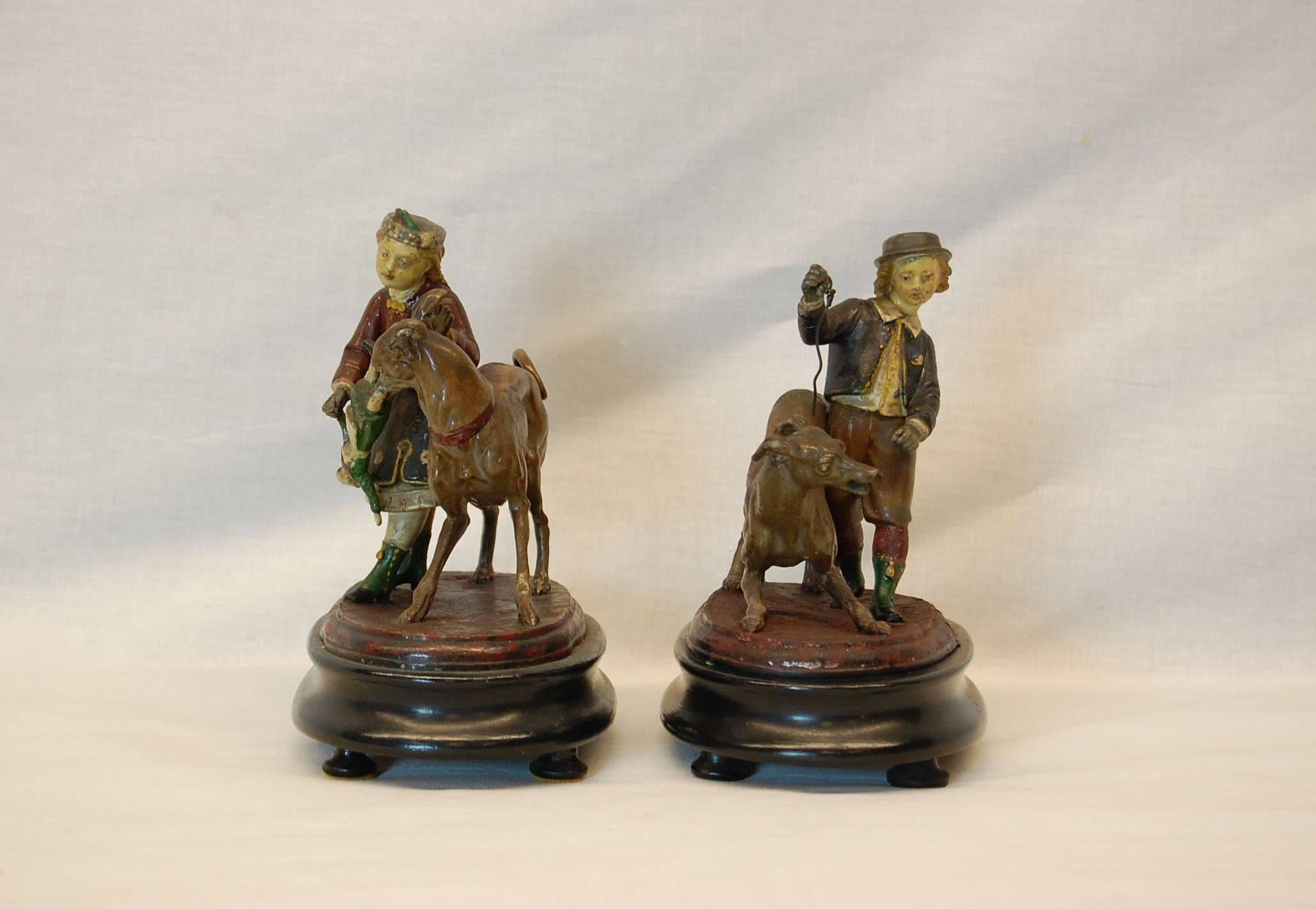 Pair of hand-painted spelter figures of children playing with their dogs mounted on original wooden bases in the manner of Georg Heyde. Paint is in original condition with very minor touch-up necessary.