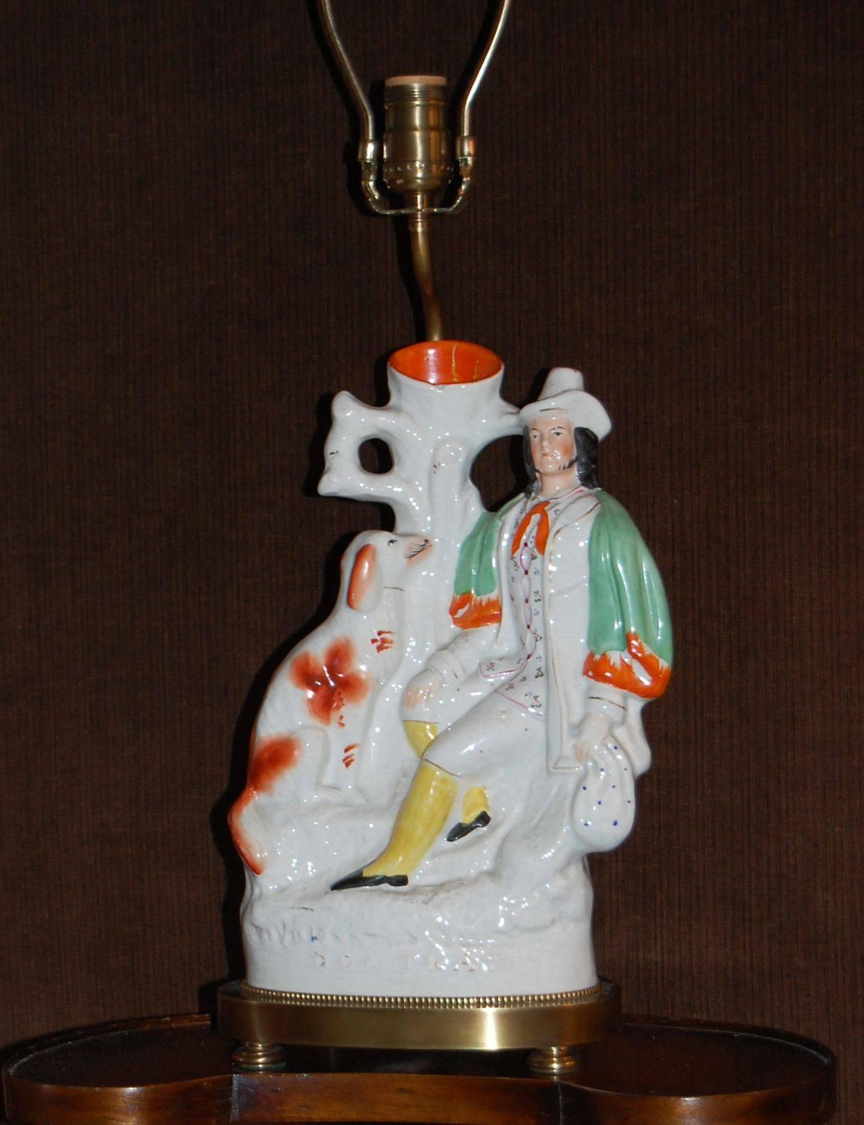 Wonderful Staffordshire vase depicting a gentleman and his dog in excellent condition. The figure sitting on the oval brass base stands 14 1/4