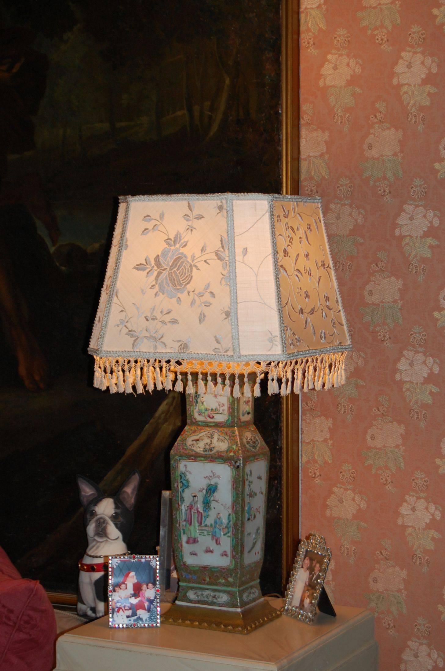 Pair of Chinese style urn lamps with custom-made embroidered silk shades with tassel trim. Gilt finished wooden bases and caps wired with three way sockets. Measures: Top of porcelain to the table is 19", shade rest is 32.5". Possibly