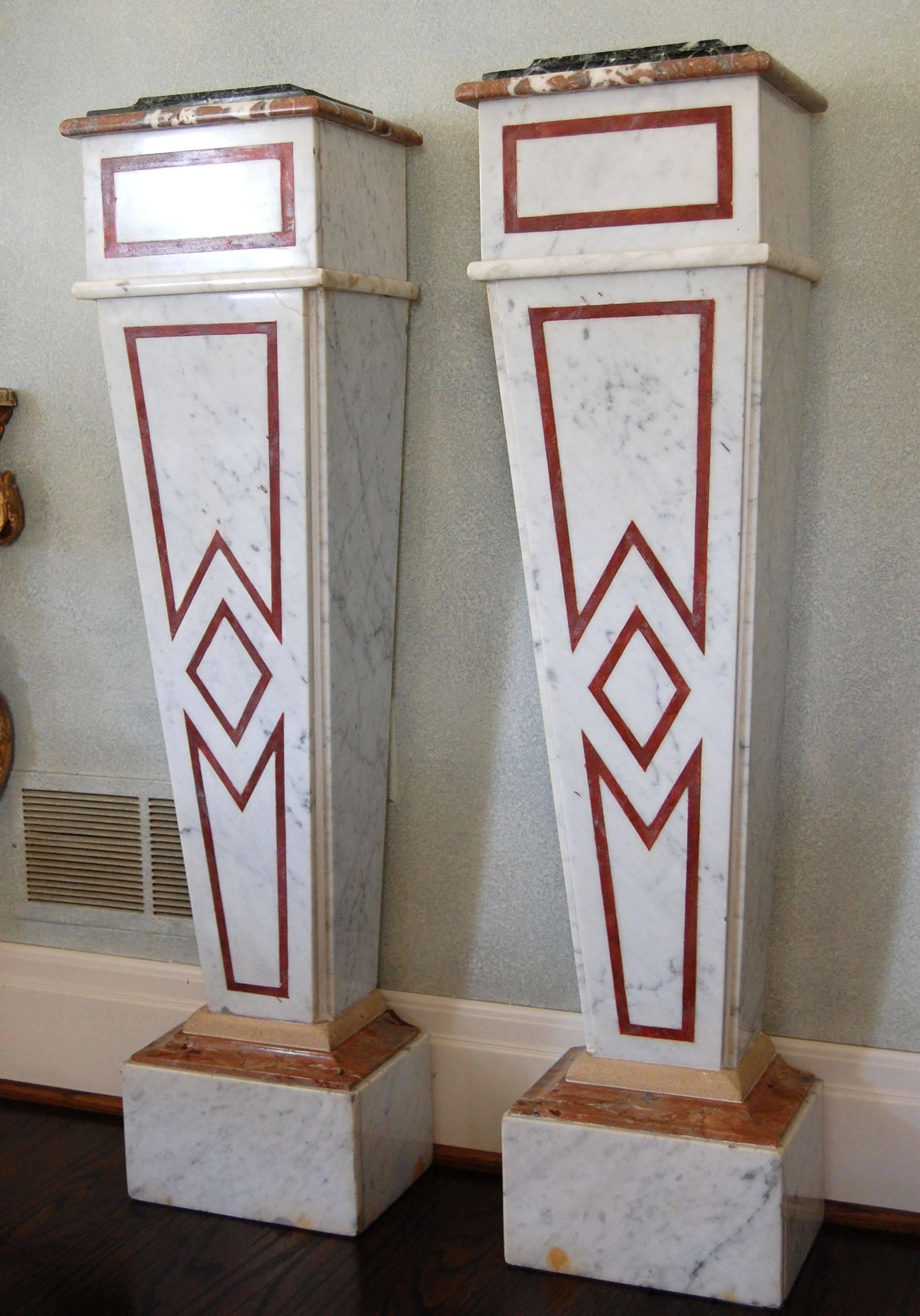 Elegant pair of marble pedestals comprised of; column: white Carrara with French rouge antique feature strip; white Carrara base with Duquesa Rosa sub cap and Beauharnais cap; Duquesa Rosa cap with Verde antique top.