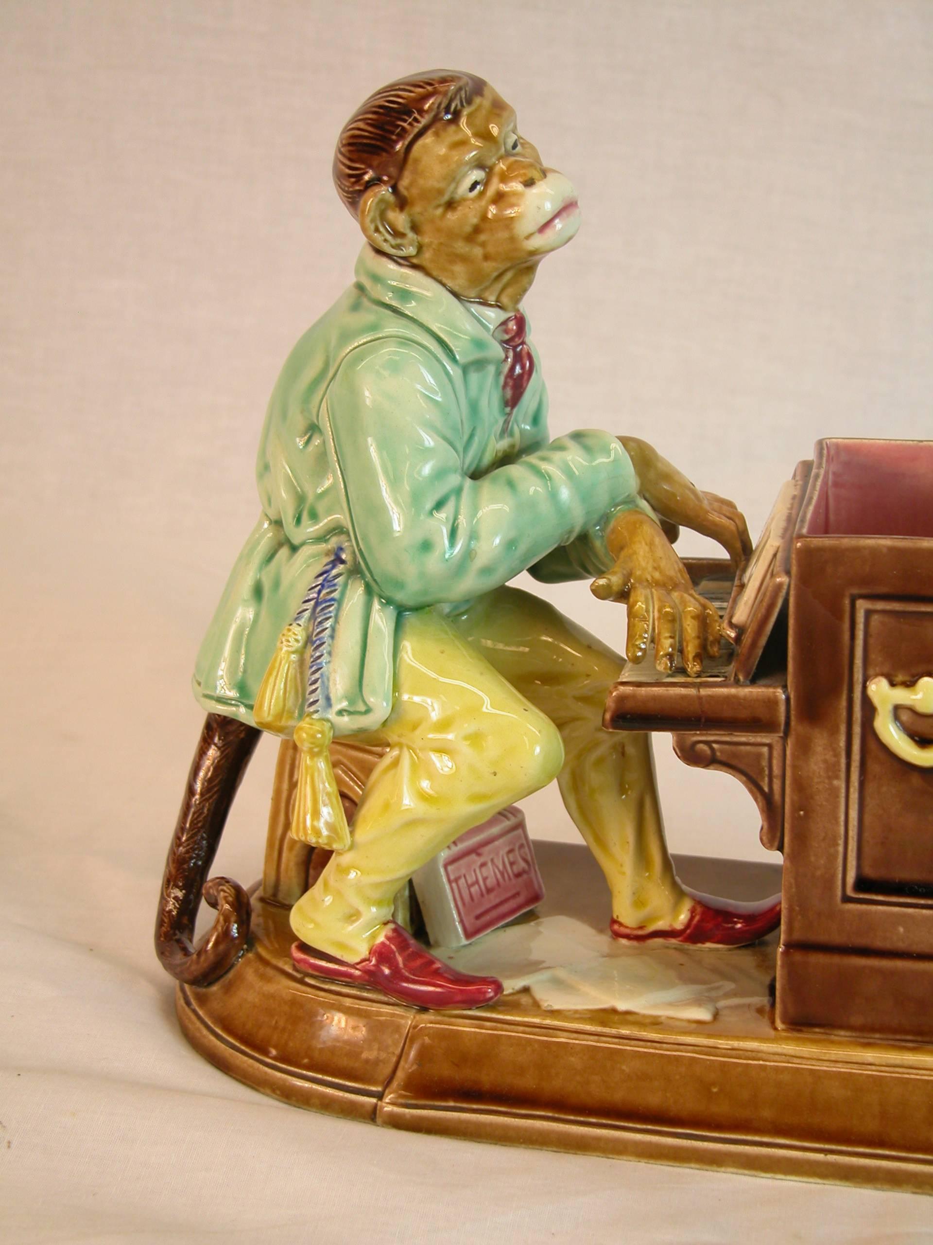 Late 19th century Sarreguemines Majolica sculpture modeled as a monkey playing the piano, brightly hand-painted in realistic colors of browns, aqua, yellow and red. Mint condition.