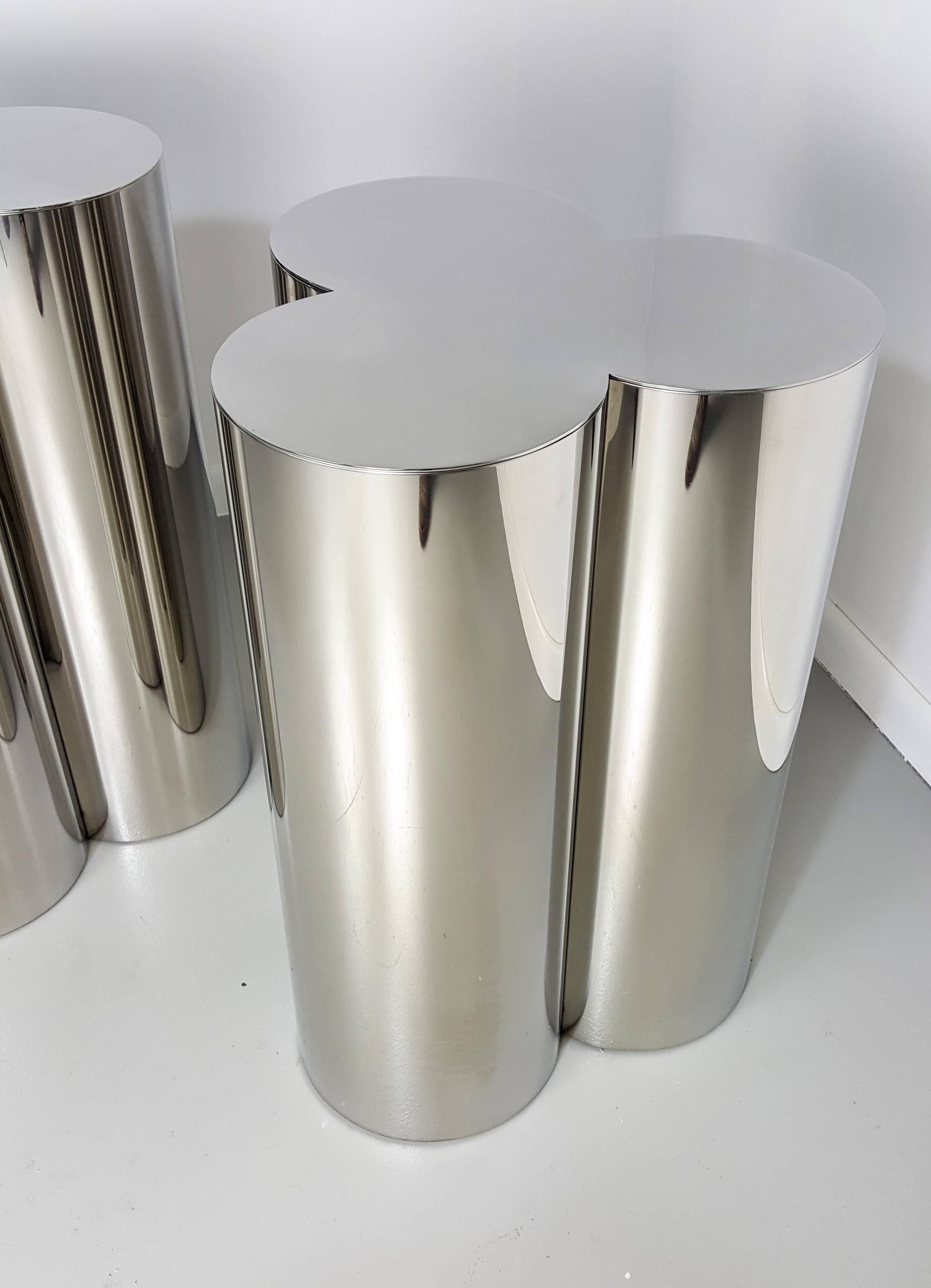 Custom Trefoil Dining Table Pedestal Bases in Mirror Polished Stainless Steel. The finish appears as chrome. This is a custom-made product that is also available in polished brass. These pedestals are Industrial quality and designed to support large