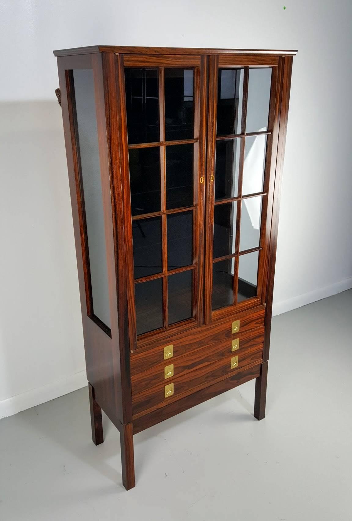 Rosewood lighted curio cabinet by Torbjørn Afdal, Norway, 1960s. Manufactured by Bruksbo. Excellent example of Classic Danish Modern / Scandinavian design. Exceptional rosewood grain throughout. Excellent condition.
