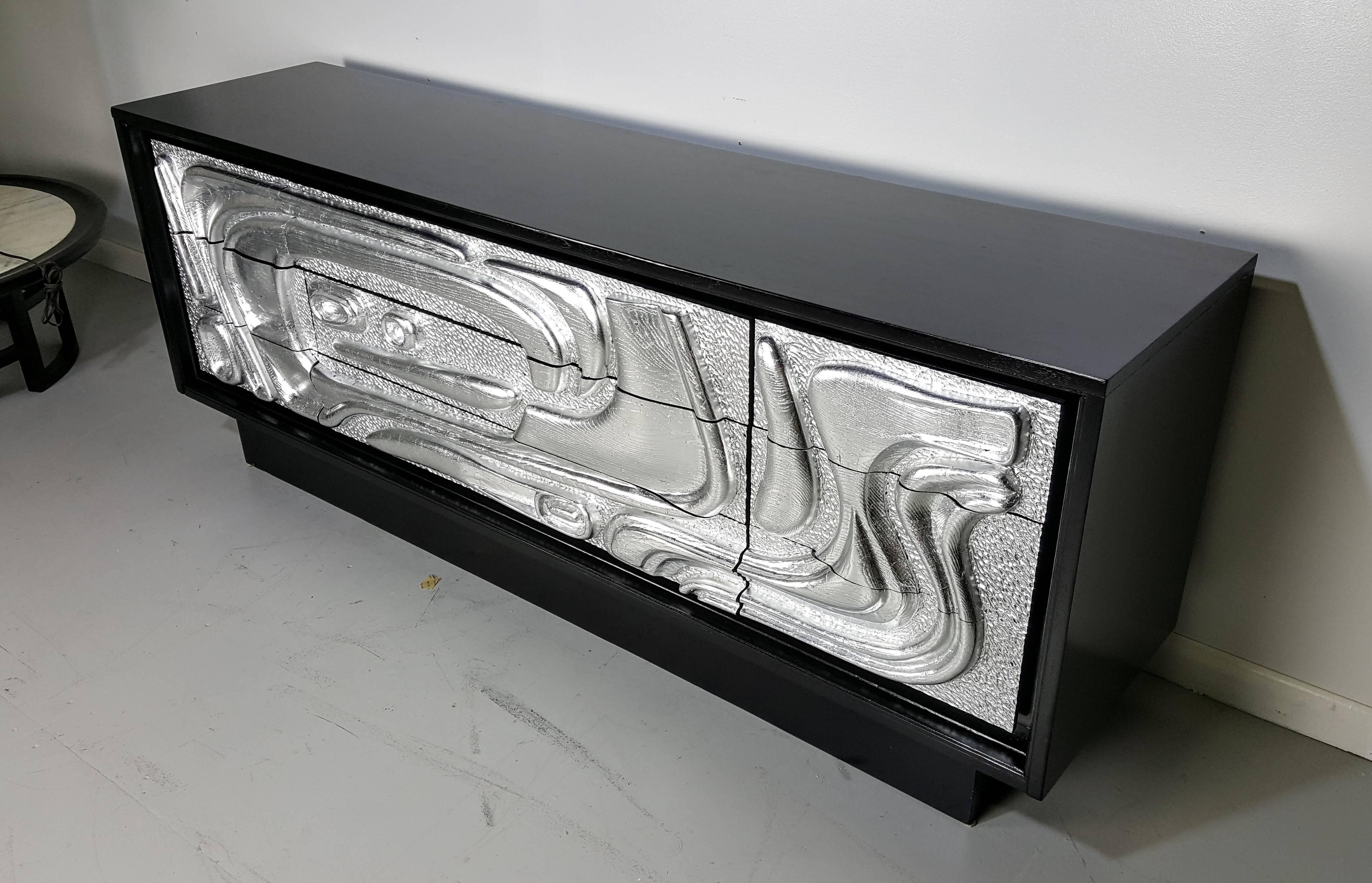 Sculptural silver leaf cabinet with Brutalist relief, ebonized case. Hand done gold leafing and lacquering. Fully restored and in excellent condition. Serves as a dresser, buffet, credenza, etc.

See this item in our private NYC showroom! Refine
