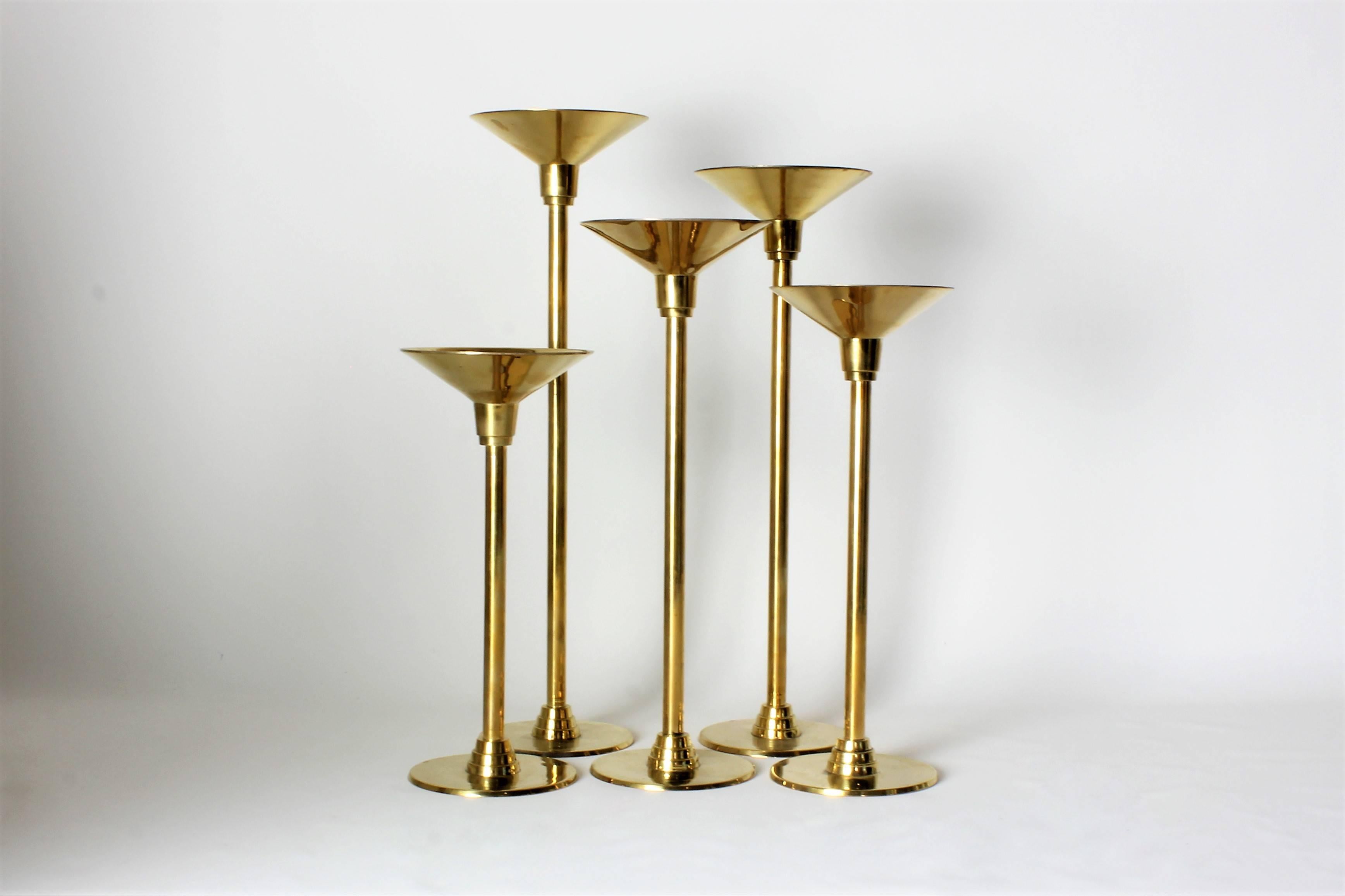 1970s Art Deco Revival brass candleholders with in graduated heights ranging from 10" tall to 16" tall. These pieces are substantial and heavy and have just been fully restored and re-plated. Bases are 4" diameter and tops are