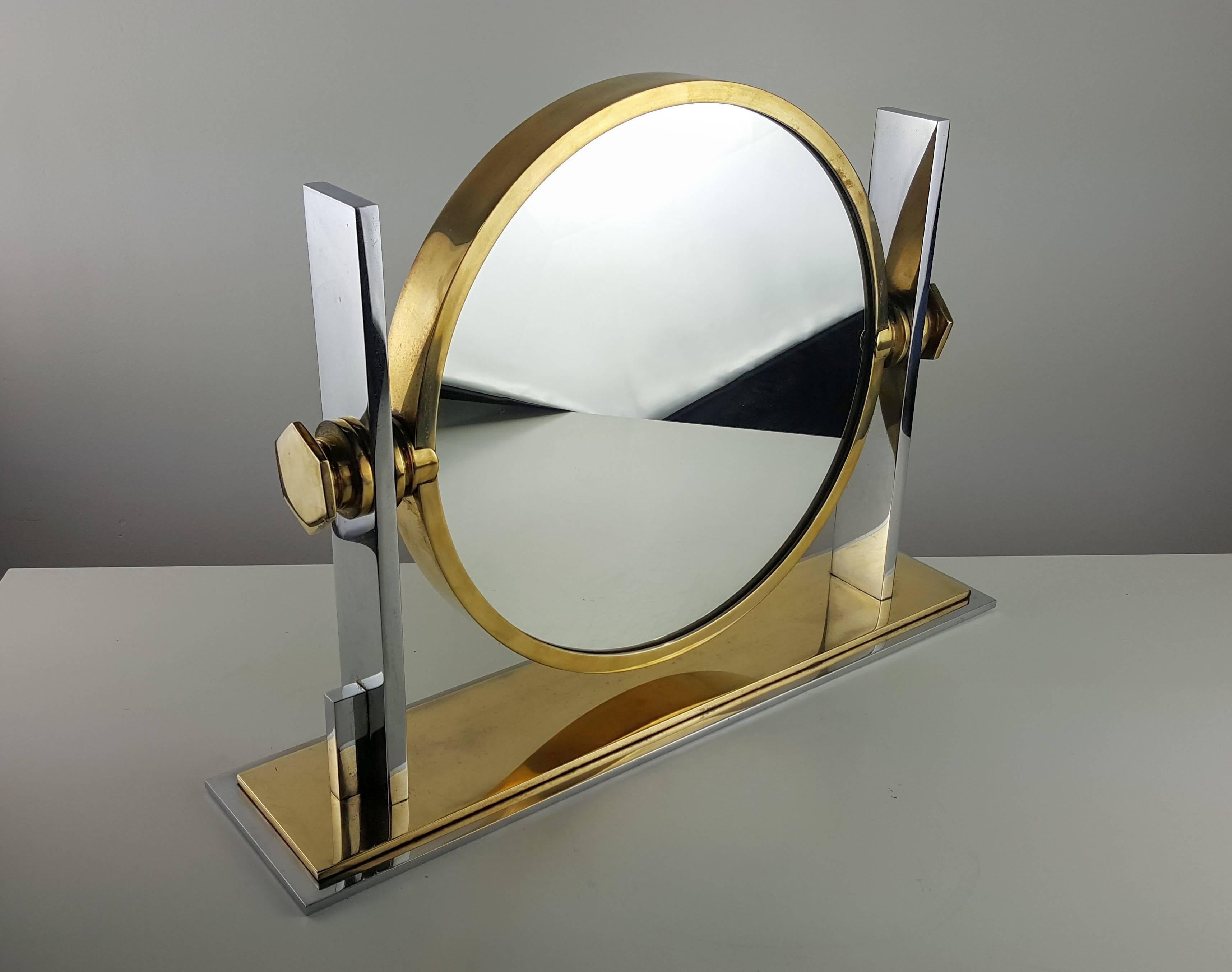 Gorgeous two-sided vanity mirror in chrome and brass by Karl Springer, 1970s. All metal parts are constructed of solid flat bar steel and brass. Very heavy and well made. Mirror on one side is flat and a magnifying convex mirror on the back. Mirror