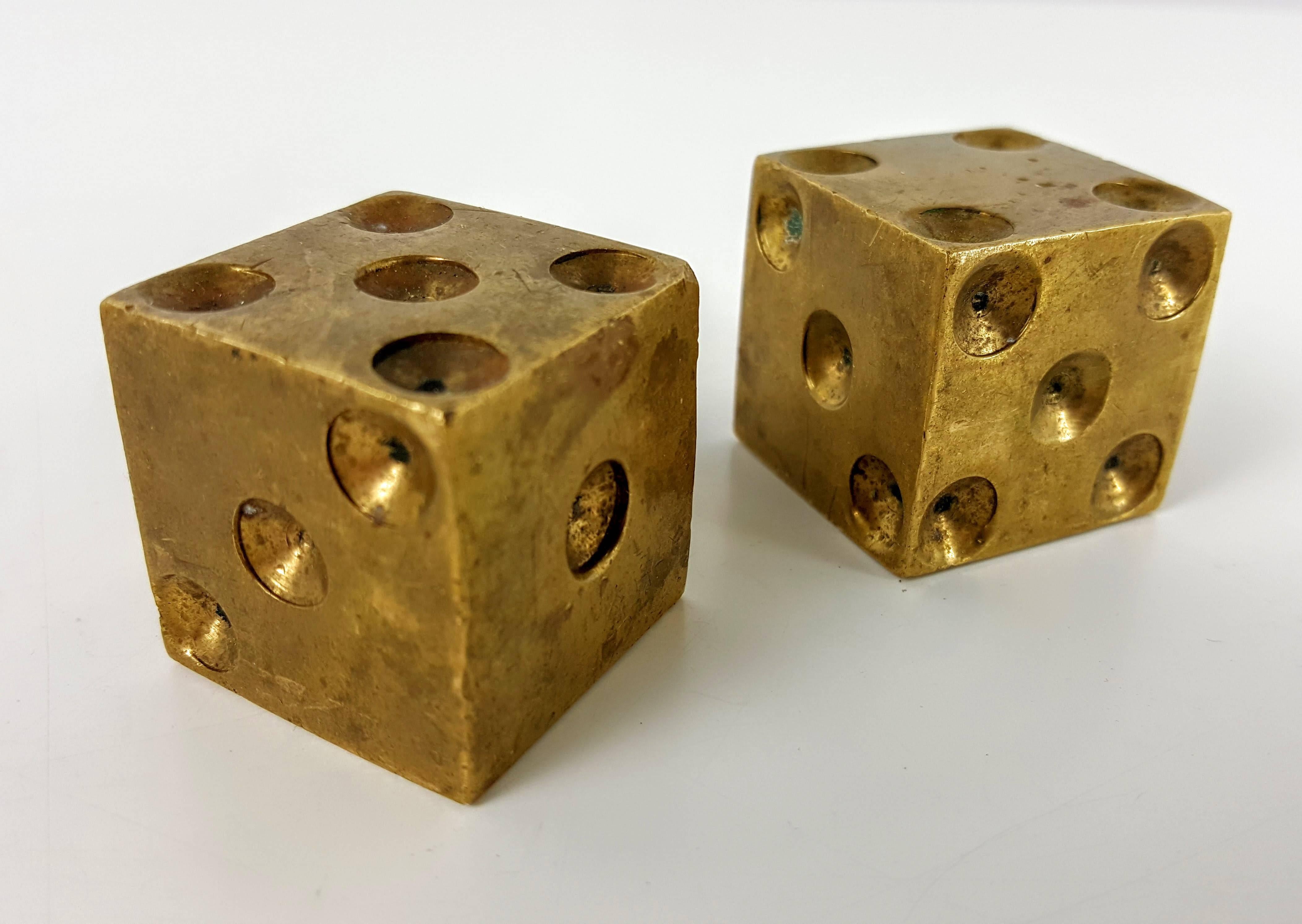 Solid brass dice paperweights or decorative objects. Machined out of solid brass. Very heavy with great patina and wear. 

