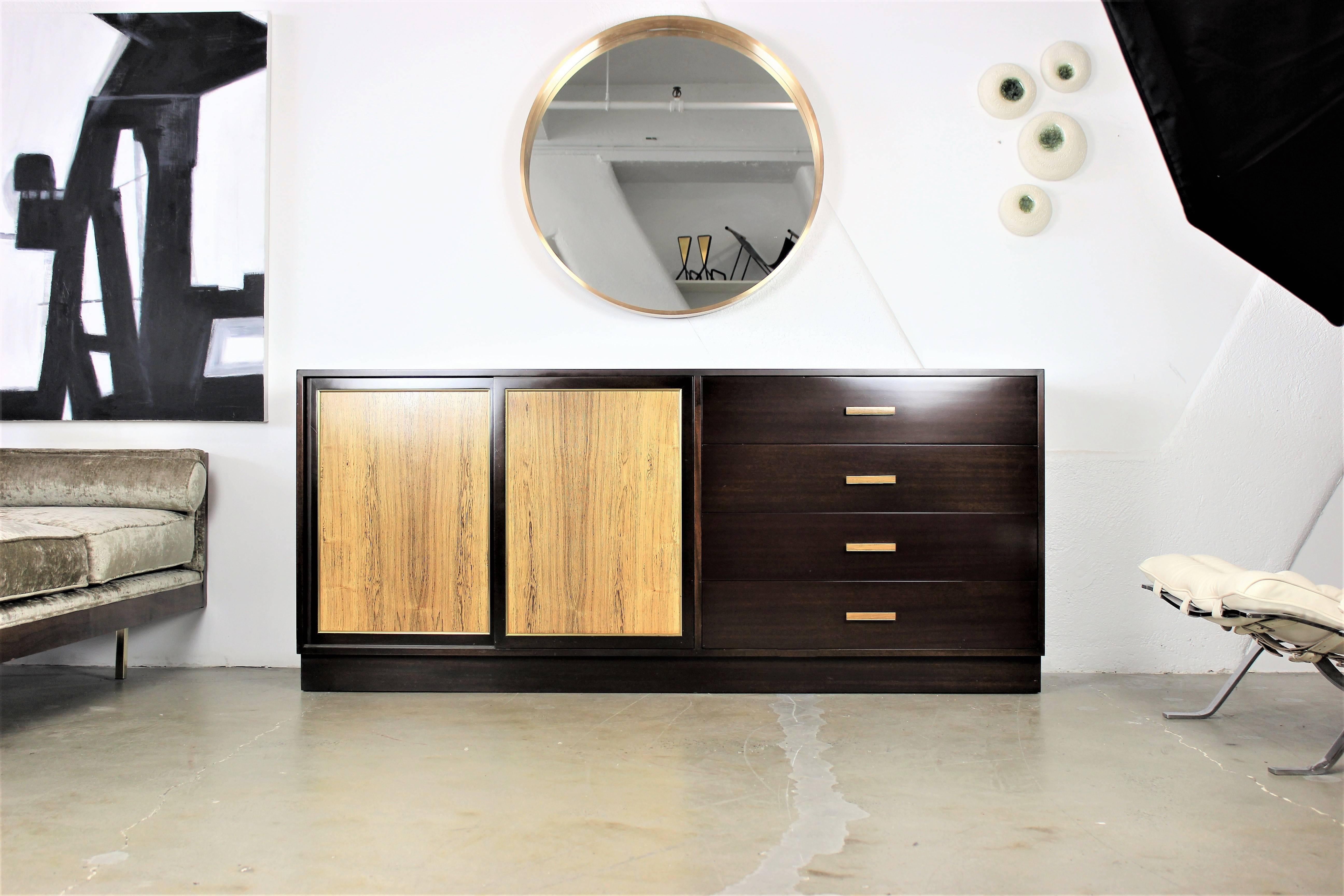 Large dresser by Harvey Probber in dark mahogany with rosewood sliding doors, 1960s. Drawer pulls are rosewood with brass detail. Classic design and tons of storage. 

Whether furnishing a contemporary Soho loft or stylish post-war Park Avenue