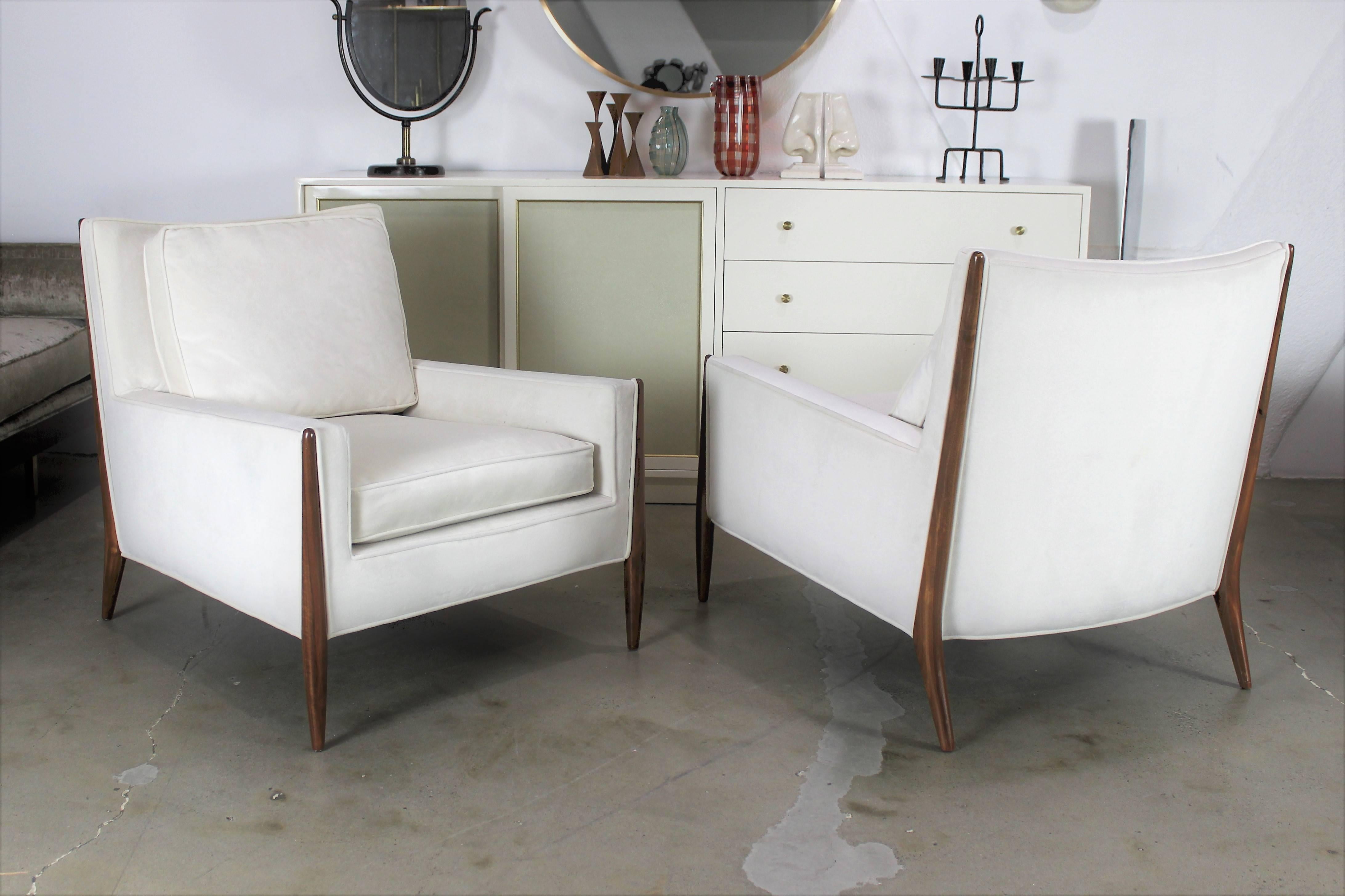 Pair of sculptural lounge chairs after Paul McCobb. Very comfortable and well made. Walnut frames have been refinished. Upholstery is a white velvet. 

See this item in our private NYC showroom! Refine Limited is located in the heart of Chelsea at