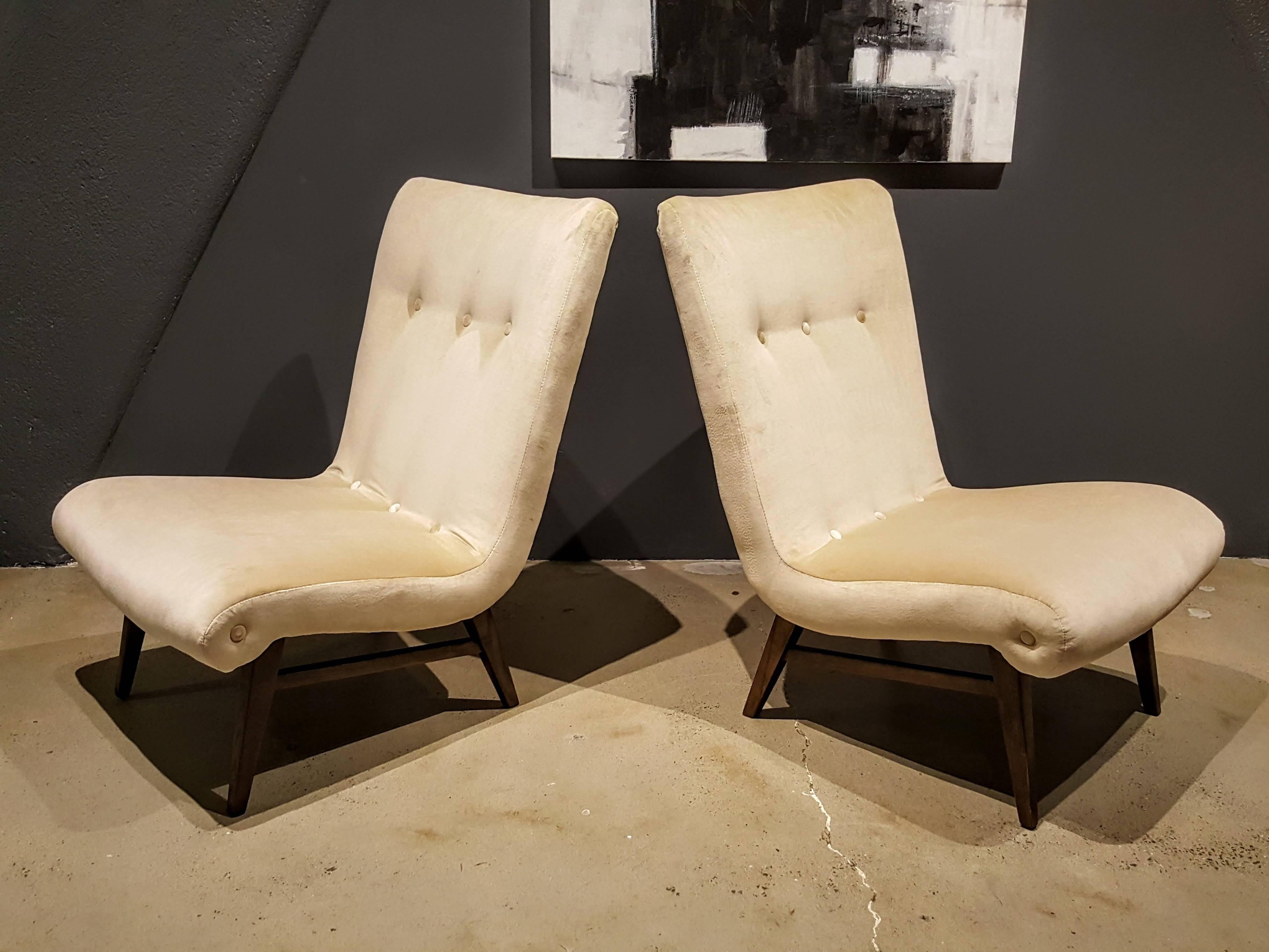 Sculptural Swedish slipper chairs in a creamy buff velvet, 1950s. Fully restored and very comfortable. The bases are mahogany with a dark finish.