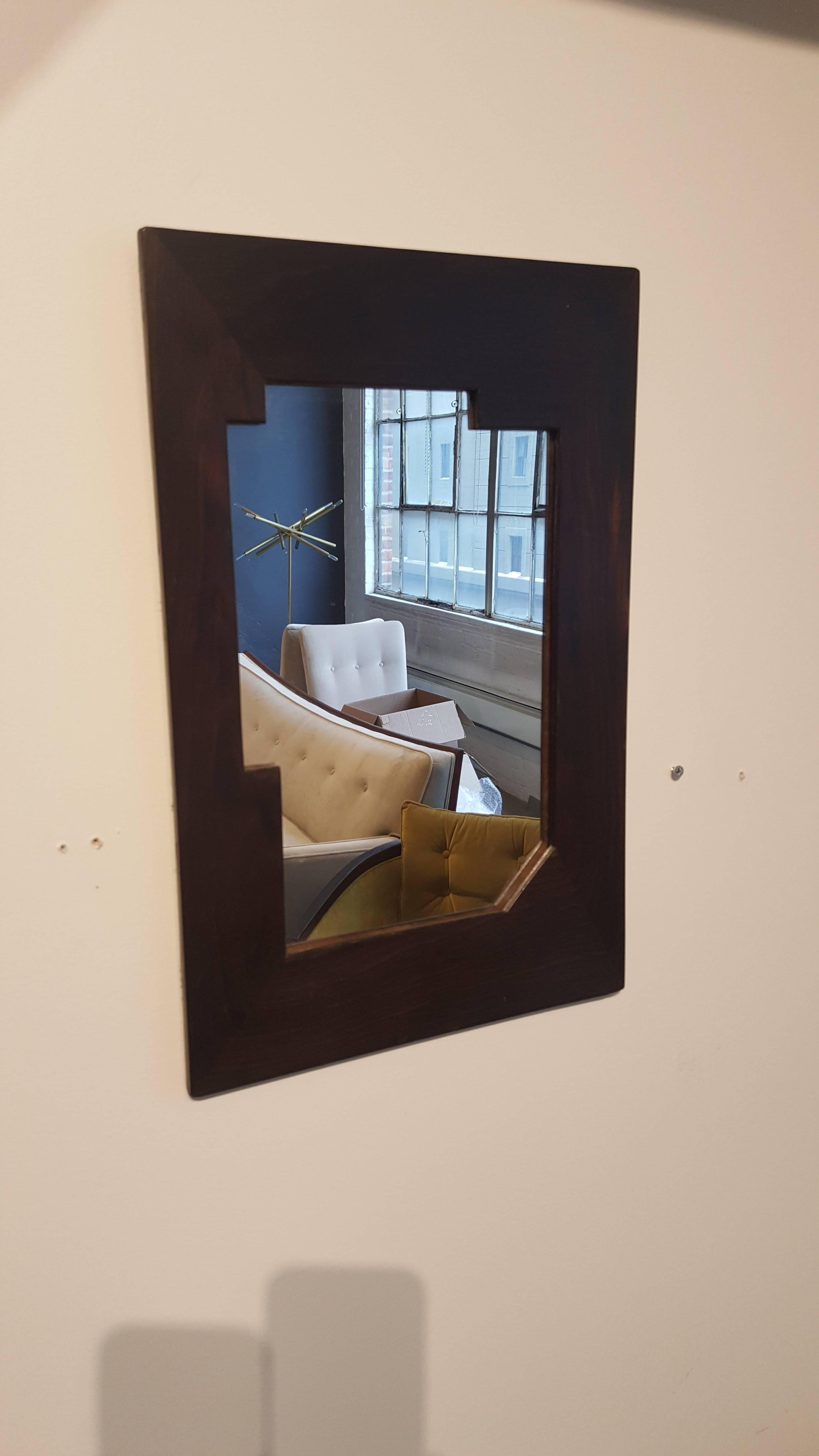 Petite wall mirror in dark rosewood, circa 1920s. The piece has stark, geometric Bauhaus lines and is in the International style. Origin and designer unknown, but likely European. In excellent vintage condition with no issues. Would be lovely in a