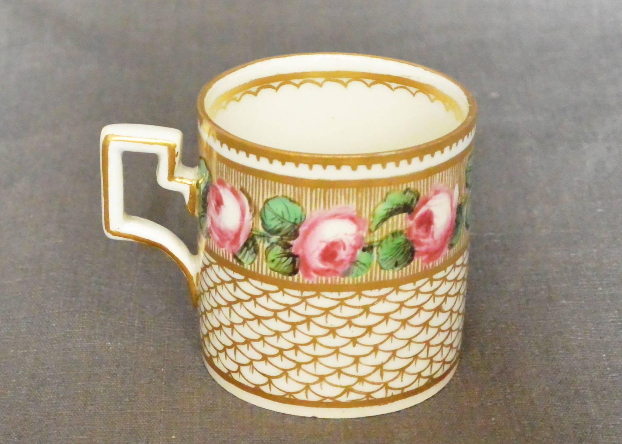 Italian gilt porcelain cup.  Real Fabbrica Ferdinandea hand-painted demitasse cup with rose painted surround above a gilt fish-scale. Band with gilt rim and handle. Underglaze marks for Real Fabbrica Ferdinandea, Naples, Italy, circa