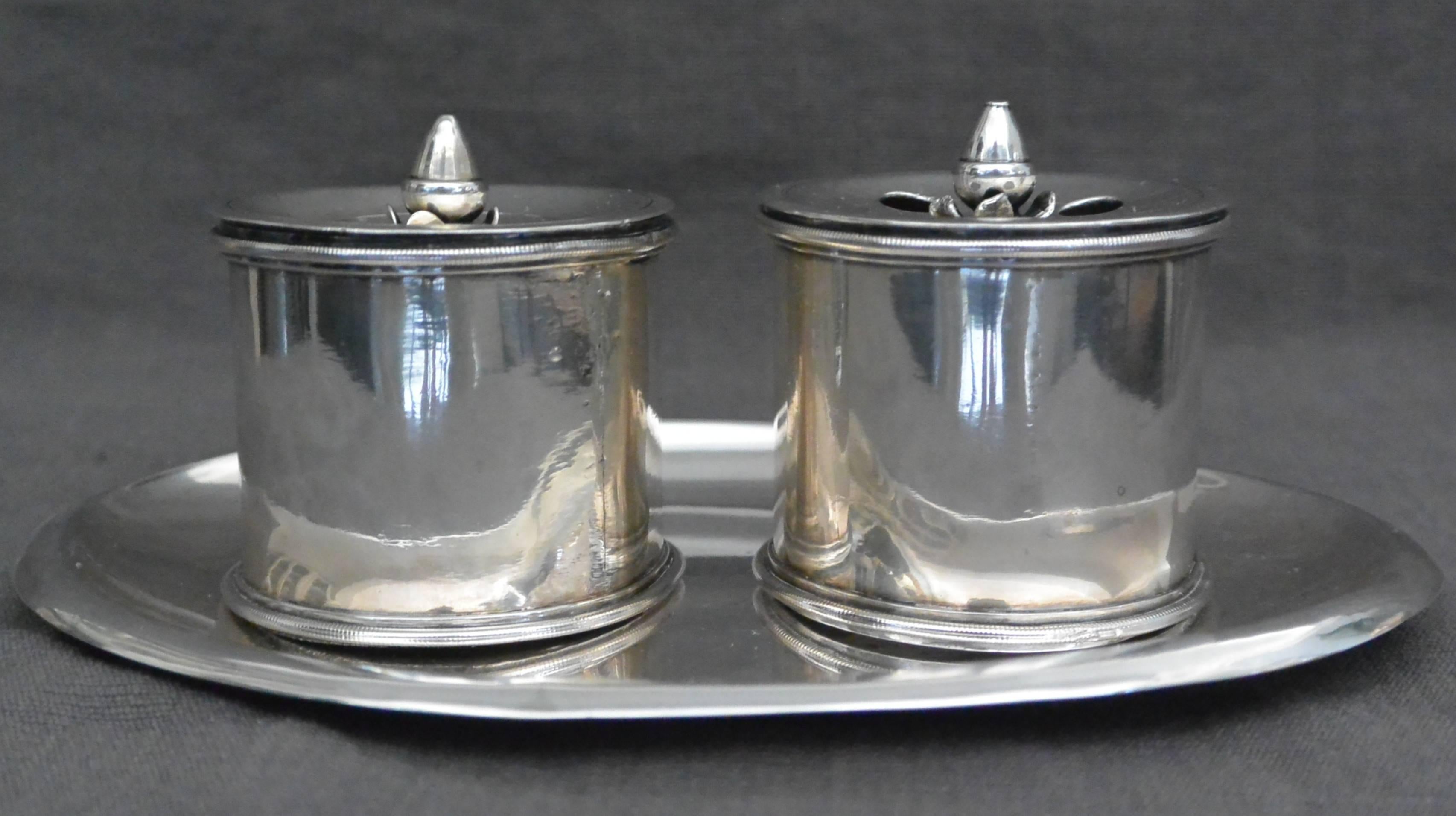 Italian Empire Silver Inkstand. Roman sterling silver inkstand of sober neoclassical form comprising double pots for sander and inkwell with acorn finial lids on a stamped oval tray, Italy, early 1800s. 
Dimensions: Inkwell diameter 2