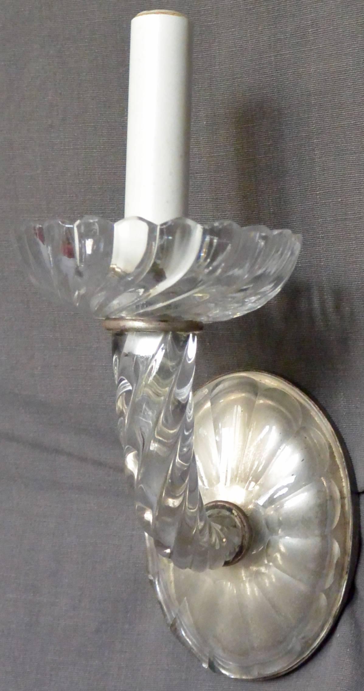 Französische Seilglasleuchte mit einer einzelnen Kerze und geriffelter Bobeche über einem gedrehten Seilarm und einer ovalen geriffelten Glas- und Stahlrückwand, neu elektrifiziert, Frankreich, um 1940. 
Abmessungen: 5.5