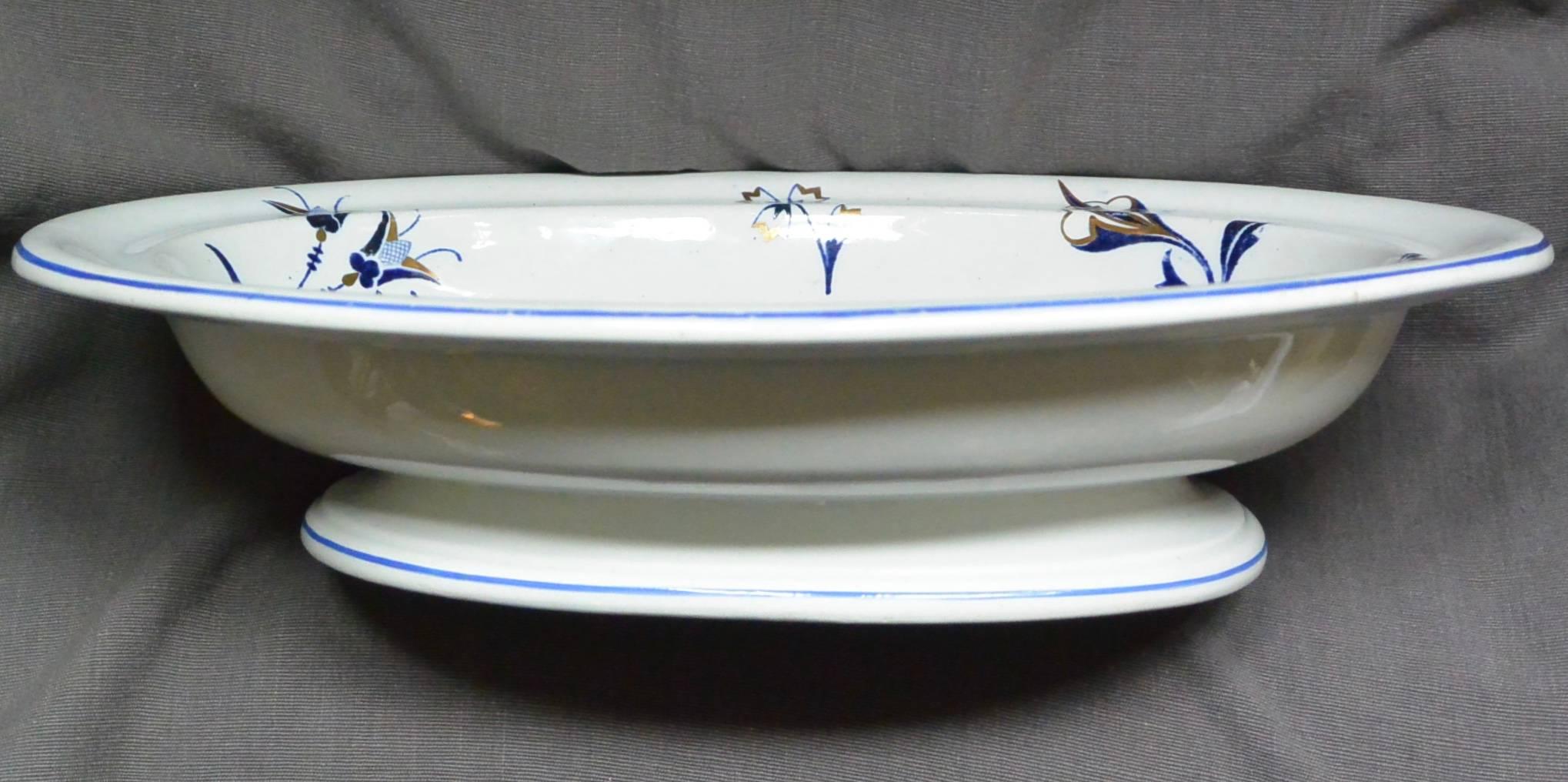 Plat à pied bleu, blanc et doré à motifs floraux de Wedgwood. Plat à pied bleu, blanc et doré avec un motif floral peint en bleu et doré. Marques imprimées pour Wedgwood, Angleterre, vers 1870. 
Dimensions : 11.75