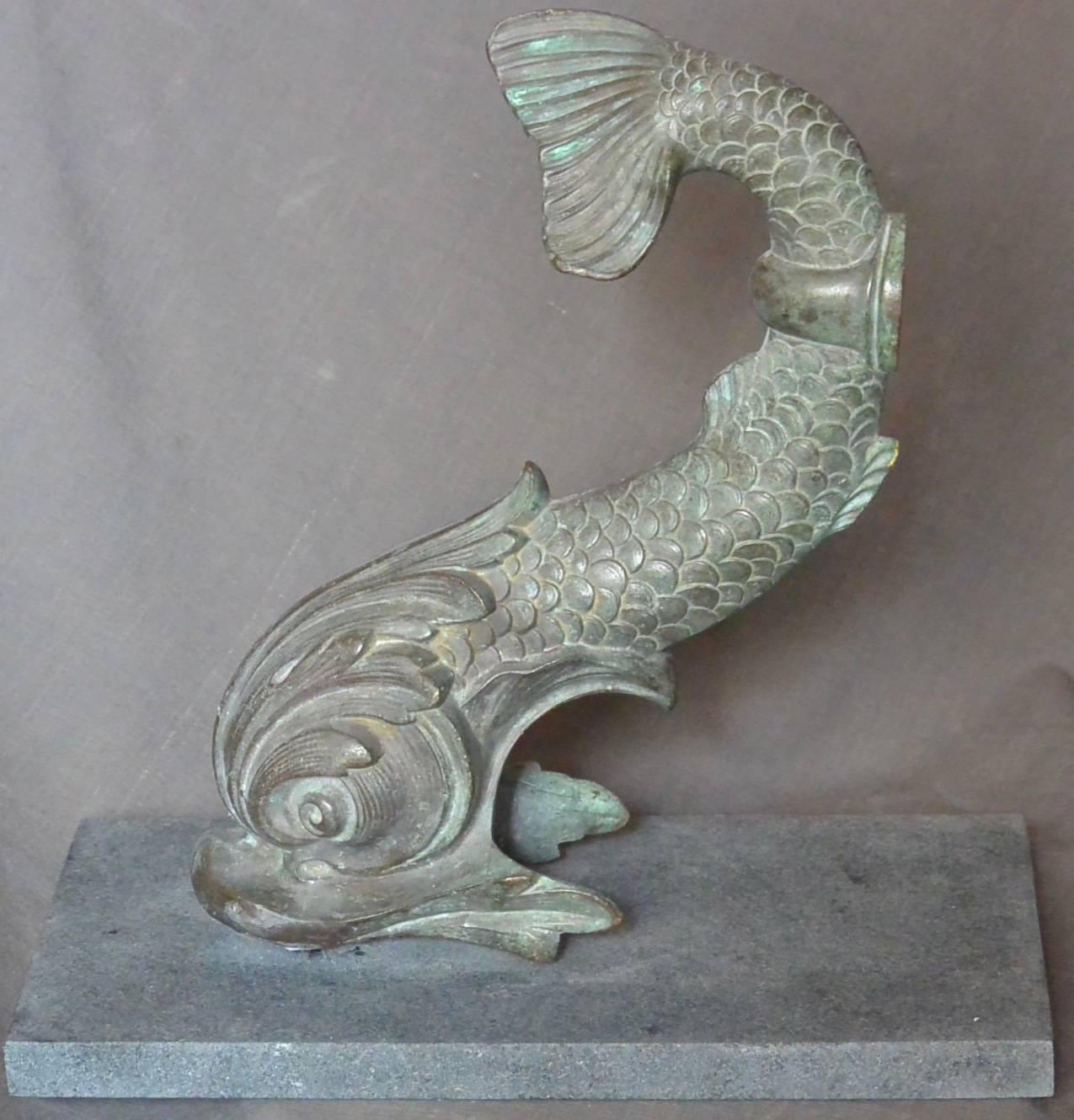Bronze dolphin sculpture. Bronze dolphin in a baroque Venetian sea serpent style mounted on black marble base; a very sculptural bookend. 
United States, circa 1900.
Dimensions: 7