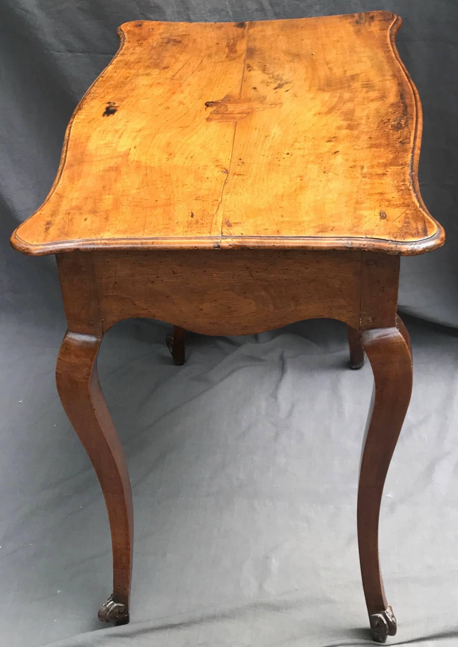 Louis XV walnut side table with a cartouche-form top above cabriole legs terminating in scroll feet; top featuring inlaid cavalier, Italy, second half of the 18th century.
Dimensions: 30