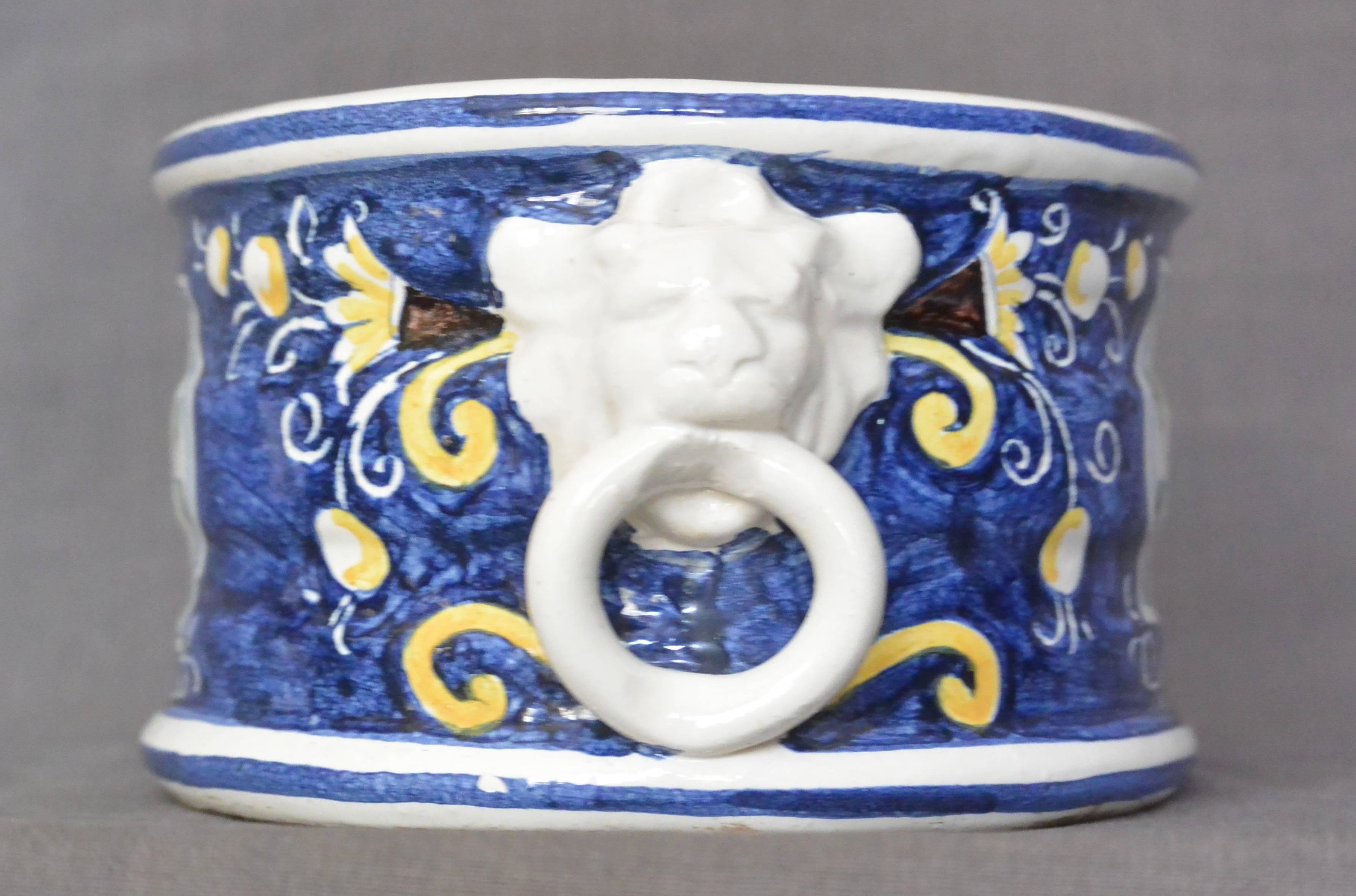 Vintage blue and white Italian cachepot, of ovoid form with lion mask ring handles and hand-painted flowers and lemons on a blue field with a central shield with floral basket Italy, mid-20th century.
Dimensions: 10.5