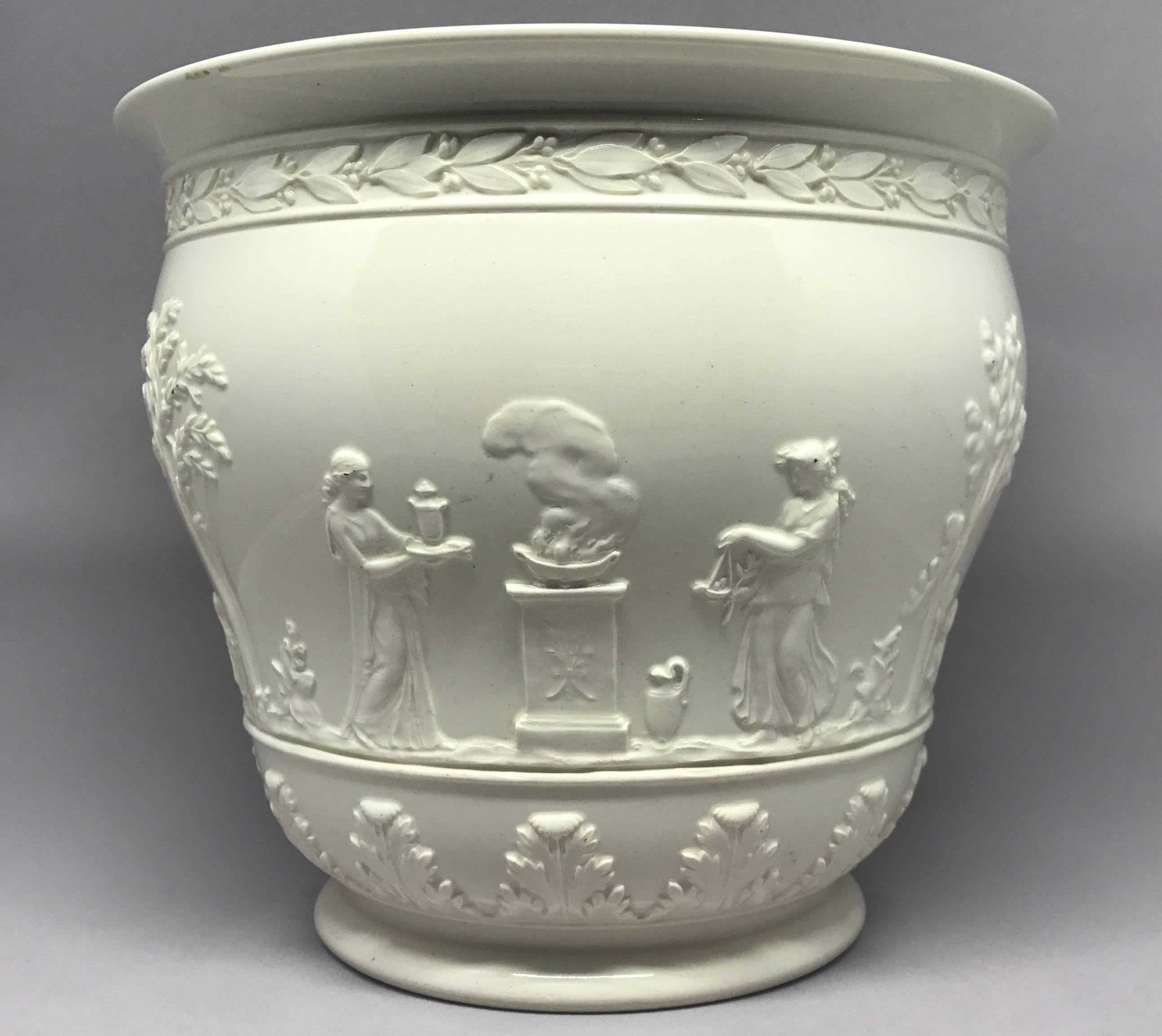 White wedgwood cachepot in the neoclassical style. Vintage cream-colored Queensware embossed flowerpot/jardiniere with markings for Wedgwood, England, late 1920s.
Dimensions: 7.25