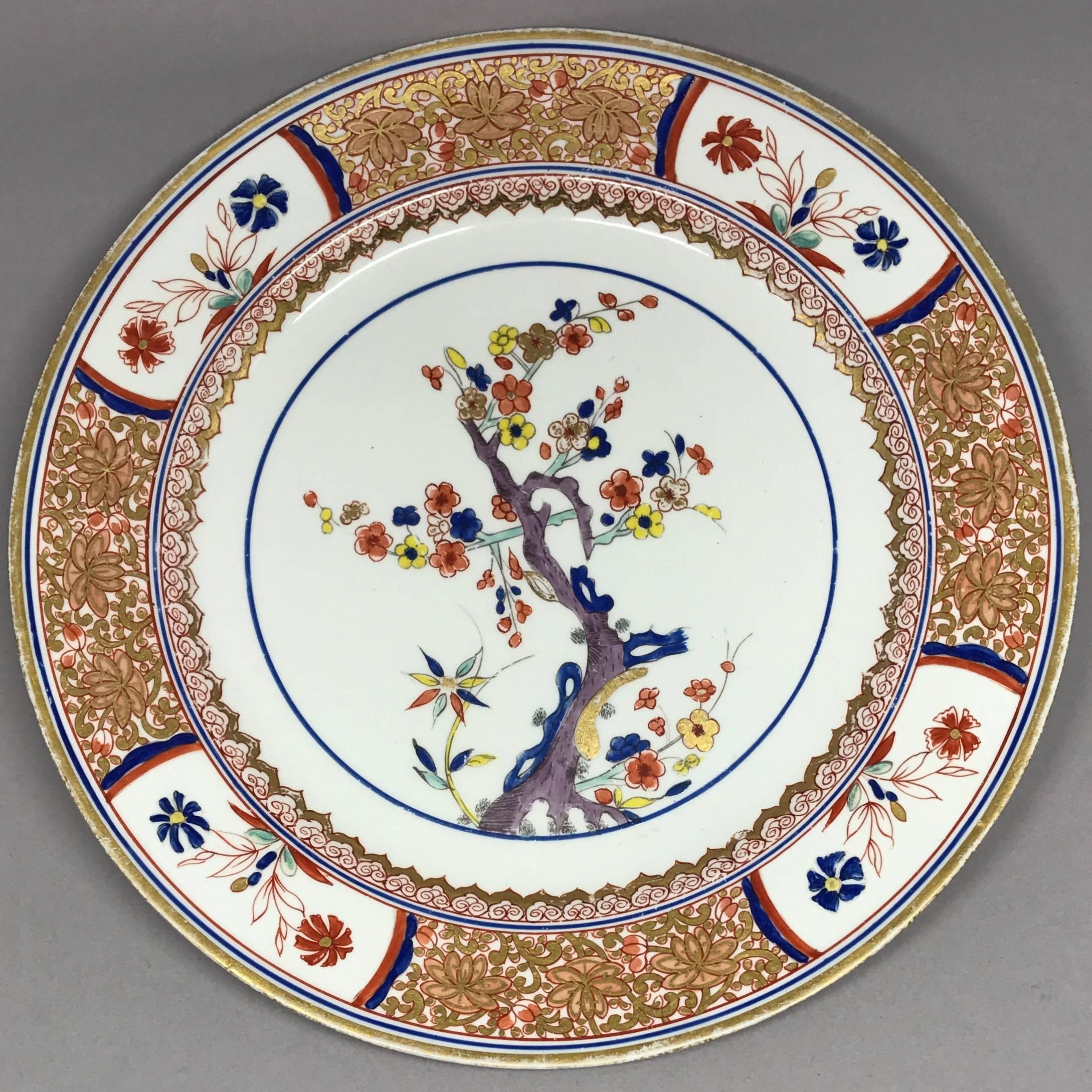 Set of four Spode gilt painted tree of life plates. Set of four perfect English plates in the kakiemon style of rich gilt and iron red scrollwork floral borders with Oriental flower reserves centering on a plum tree in purple with blue, yellow and
