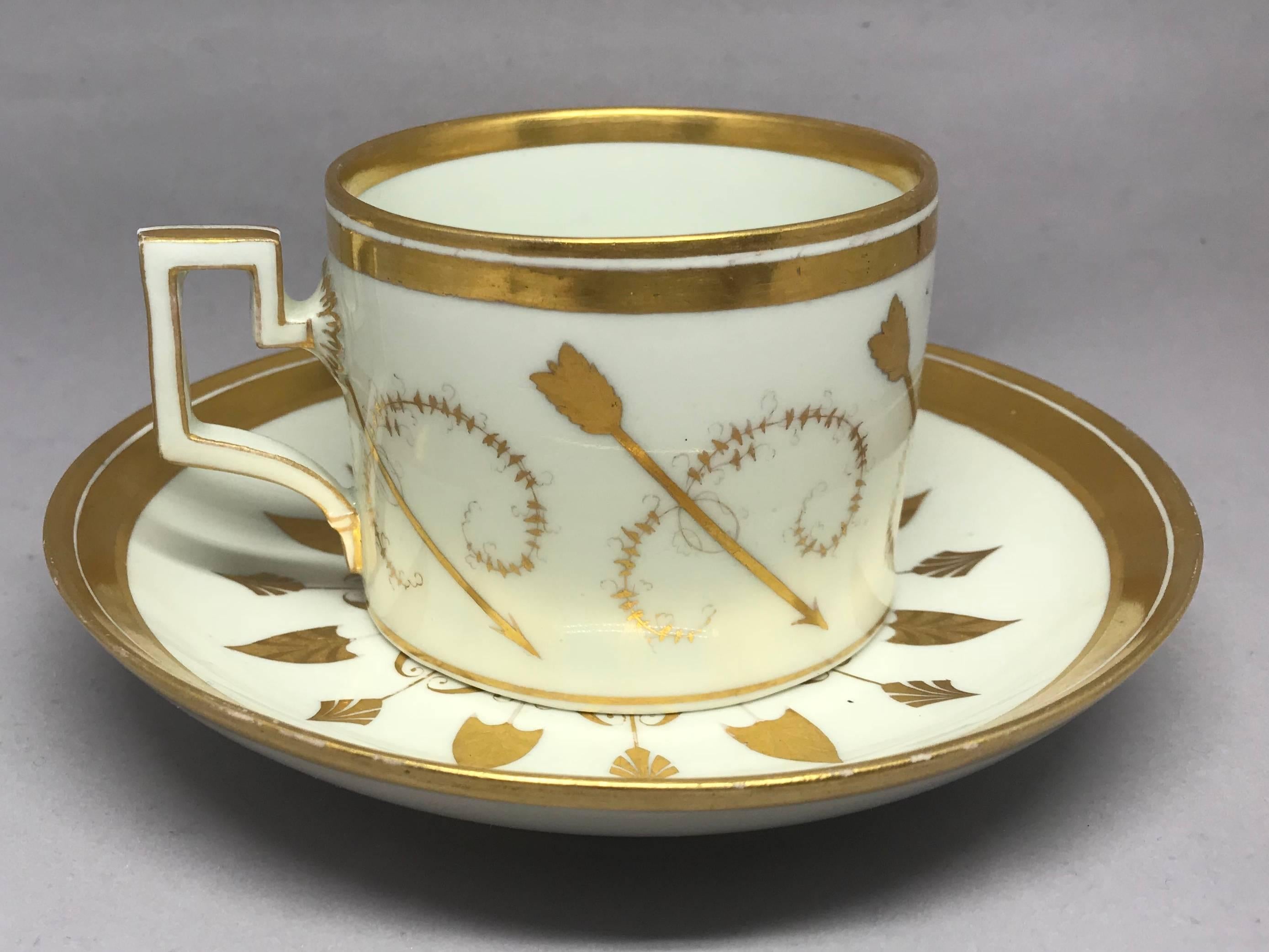 Weiß und vergoldet neoklassizistische Arrow Tasse und Untertasse. Weißes und vergoldetes Porzellan aus der Empire-Zeit mit Amor-Pfeilen und Blumenspritzern.  Unterglasurmarken für Wien.  Österreich, um 1815.

Markierungen: Wiener Unterglasurblau. 