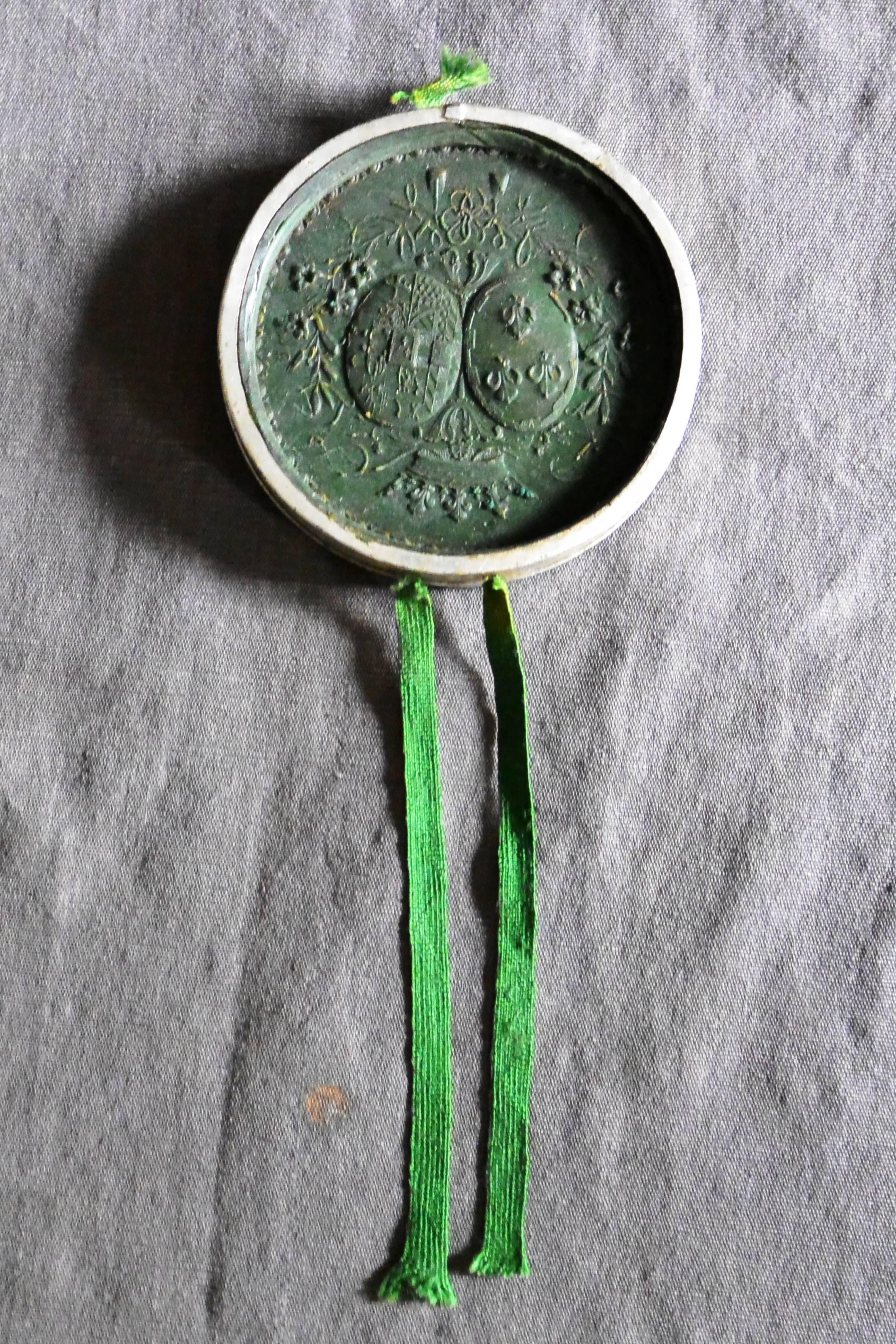 The Duchesse De Berry's wax seal. Dark green wax impression of the Duchess's royal coat of arms contained within it's original tin case with green ribbons; the exterior inscribed: Duchesse de Berry, France, circa 1816
Dimension: 3.88
