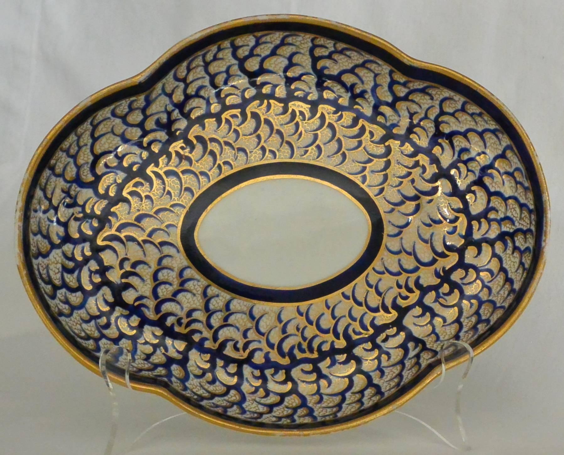 Pair Derby Blue and Gold Plates. Pair shaped plates in the form of lobed trays in rich blue and gilt painted fish-scale pattern. Red underglaze markings for Derby with crown and crossed batons. England, circa 1820
Dimension: 10
