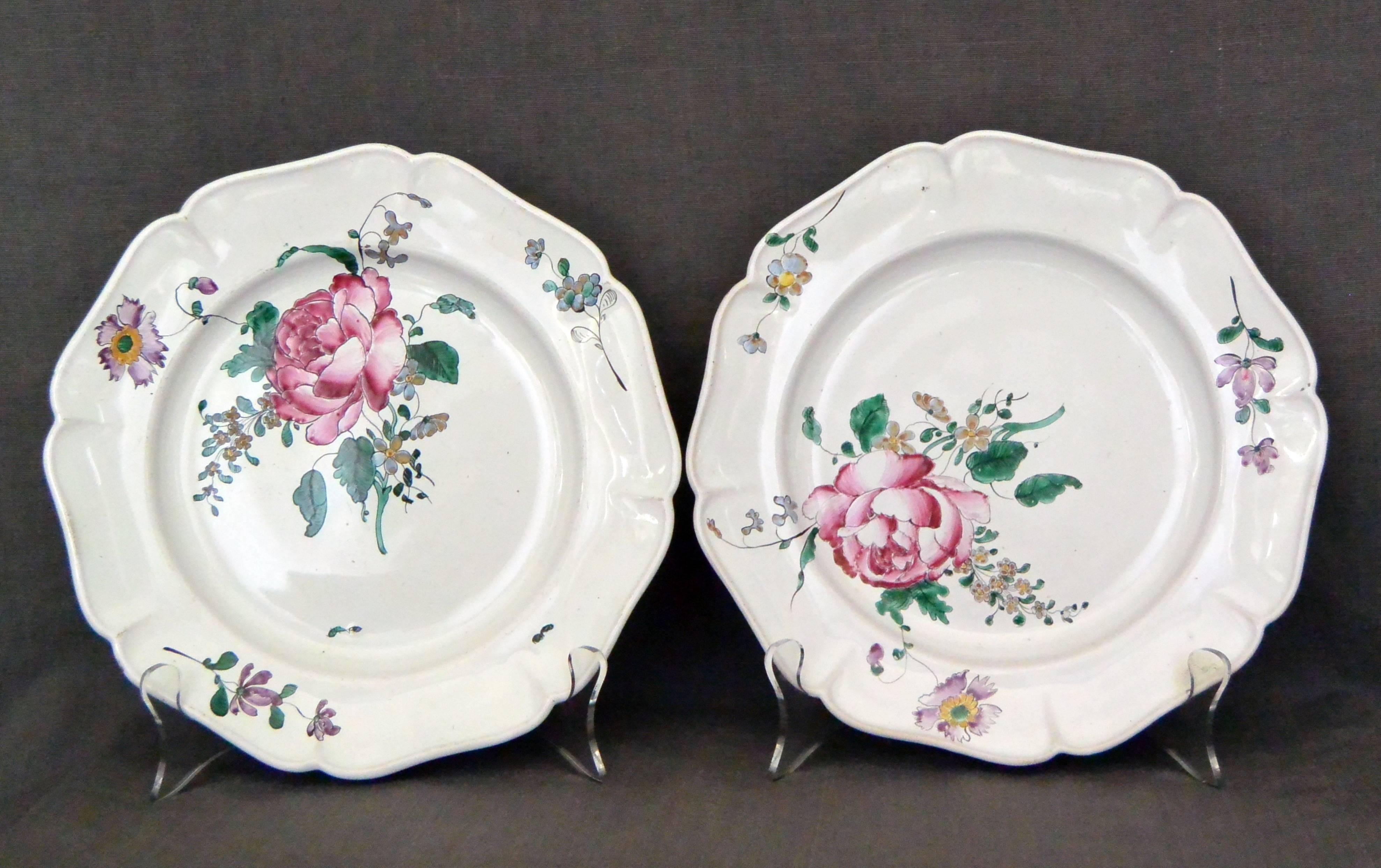 Pair of Strasbourg faience floral plates. Antique faience plates with large floral bouquets and lobed rims with further floral sprays and insects; with blue underglaze markings for Hannong Factory, France, circa 1750. 
Dimension: 9" diameter x