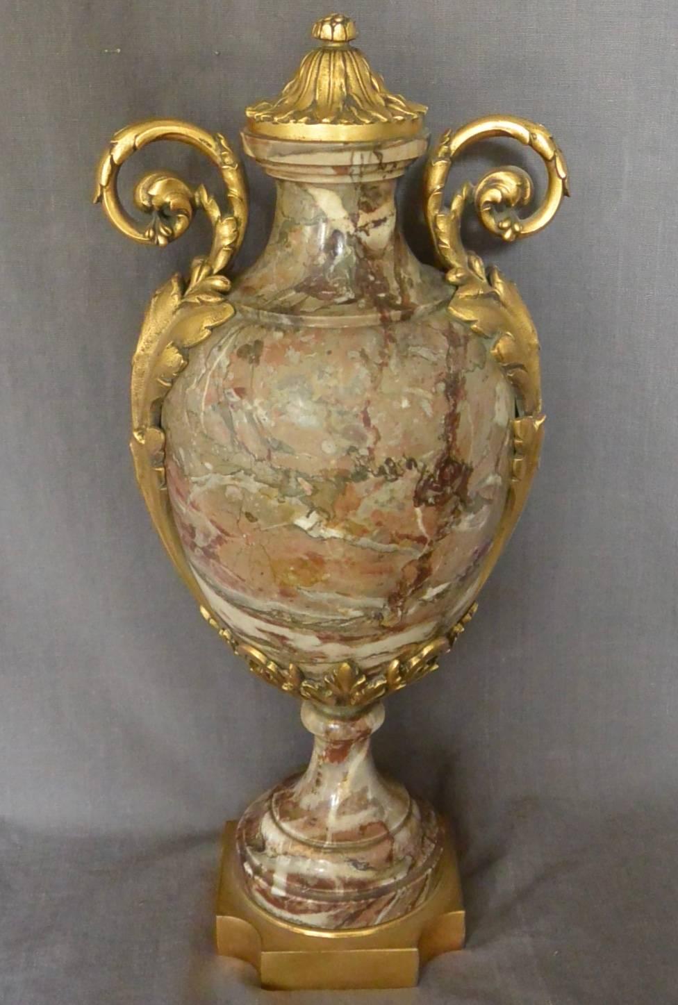 Continental ormolu-mounted marble urn. Onyx stone urn in browns, beige and grey cream with foliate ormolu outward scrolling handles and richly chased lid all on incurving square base. Europe, circa 1870
Dimensions: 8.5