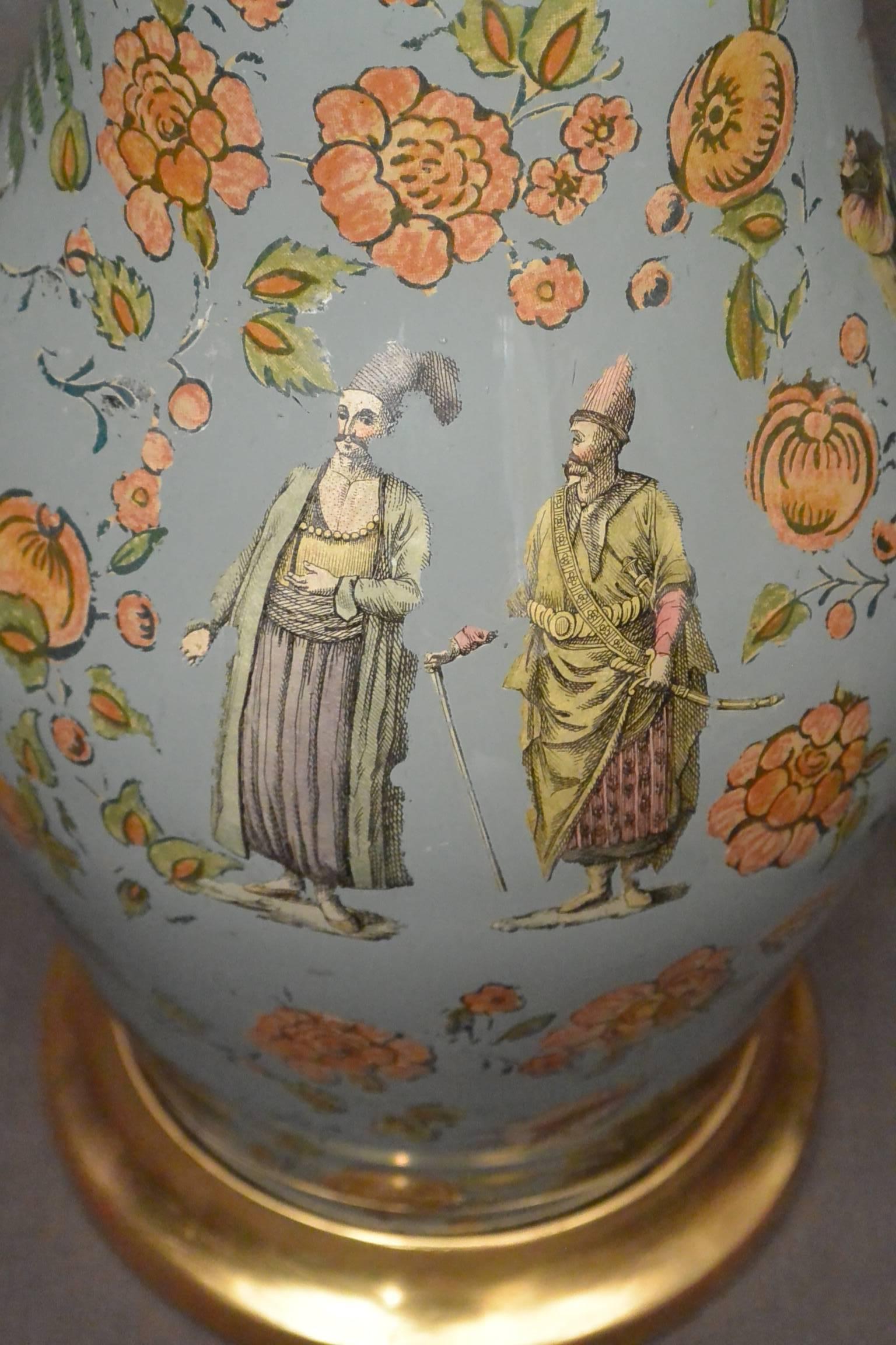 Continental chinoiserie decalcomania lamp. Continental chinoiserie decalcomania lamp on water-gilt base with Turkish court figures, Chinese figures in landscapes with scattered flowers and other chinoiserie elements on a blue painted ground, with