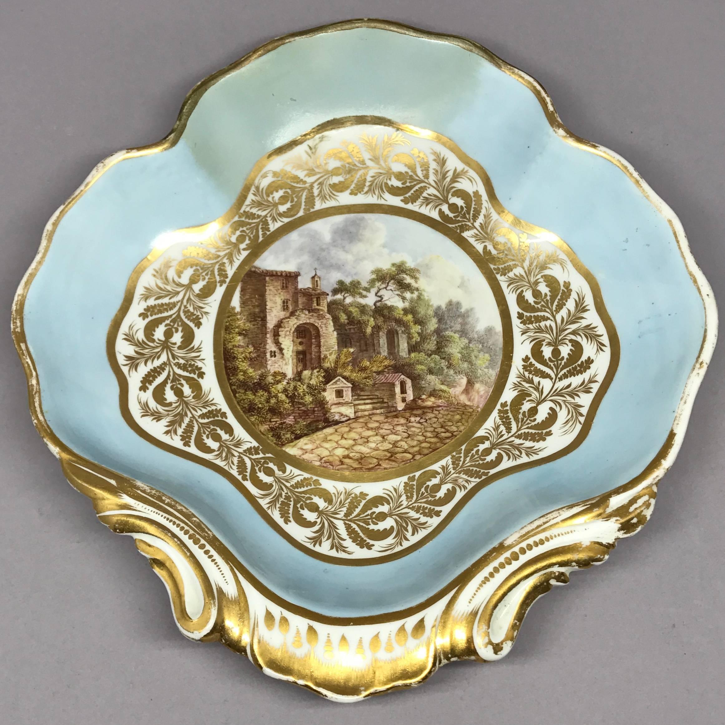 Derby gilt Italian scene shell form serving dish. Antique Derby sweetmeat plate with gorgeous gilt floral banding inside pale blue gilt border centering on painted view of the 