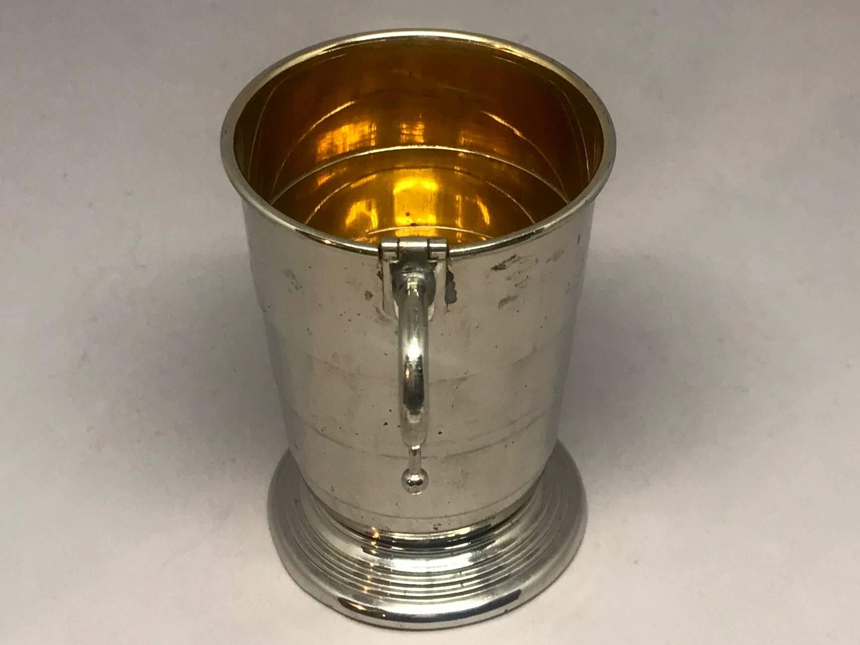 Collapsible German silver and vermeil cup. Chic camping cup: vintage silver plated and vermeil washed interior campaign cup of ingenious collapsible design with operable hinged handle, retailed by Mark Cross London, Germany, circa 1910.
Dimensions: