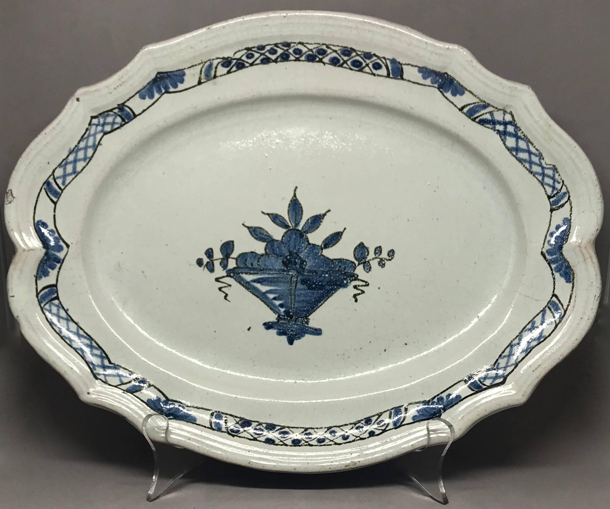 Rouen blue and white faience platter. Shaped oval earthenware white glazed platter with blue decorative banded border centering on a stylized fruit basket of the cul noir process possibly from Eaux-des-Forges outside Rouen. France, 19th